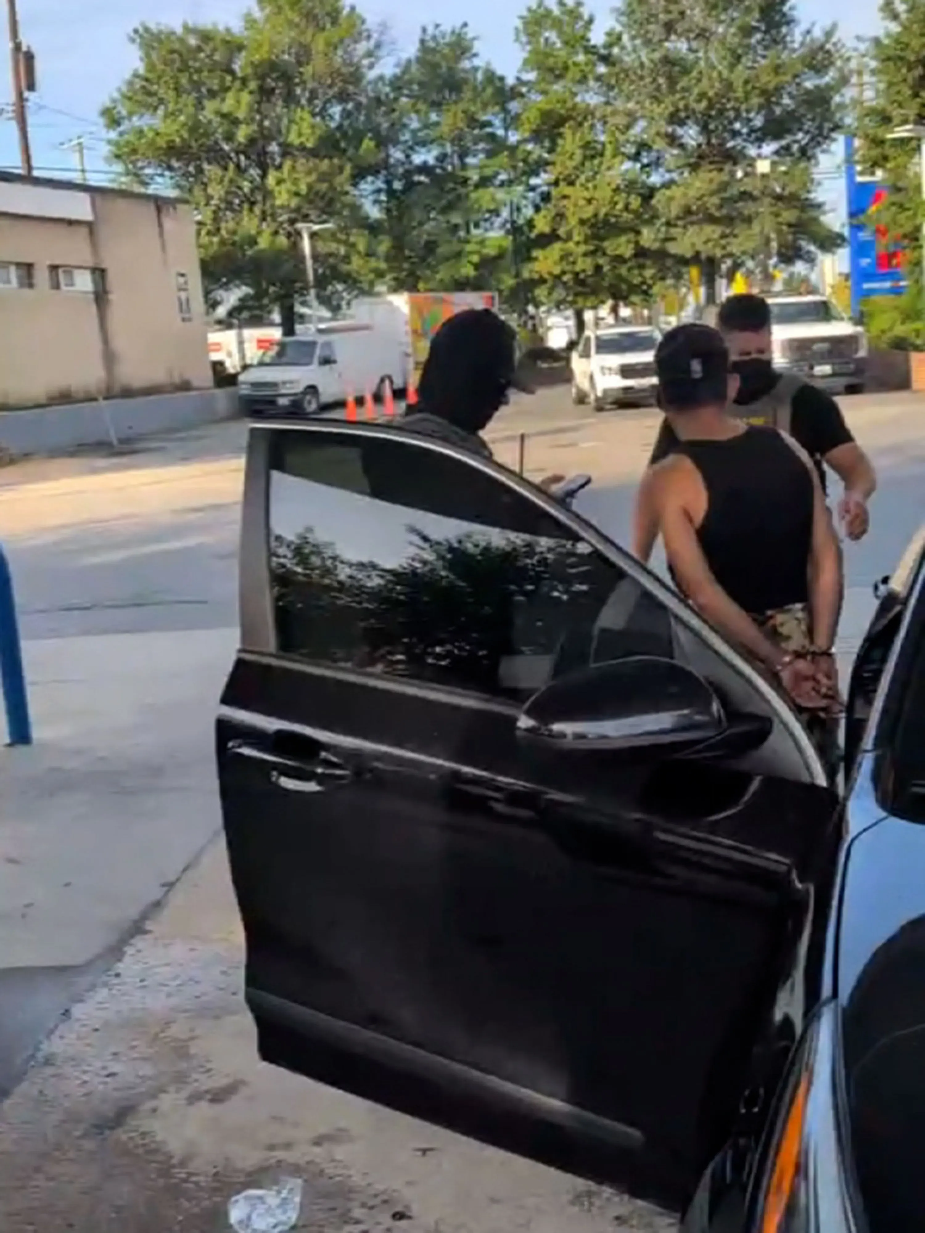 عملية اعتقال من وكالة إنفاذ قوانين الهجرة والجمارك في محطة وقود، حيث يُقيّد رجل يُدعى صموئيل بينما يتواجد رجال ملثمون ومسلحون.