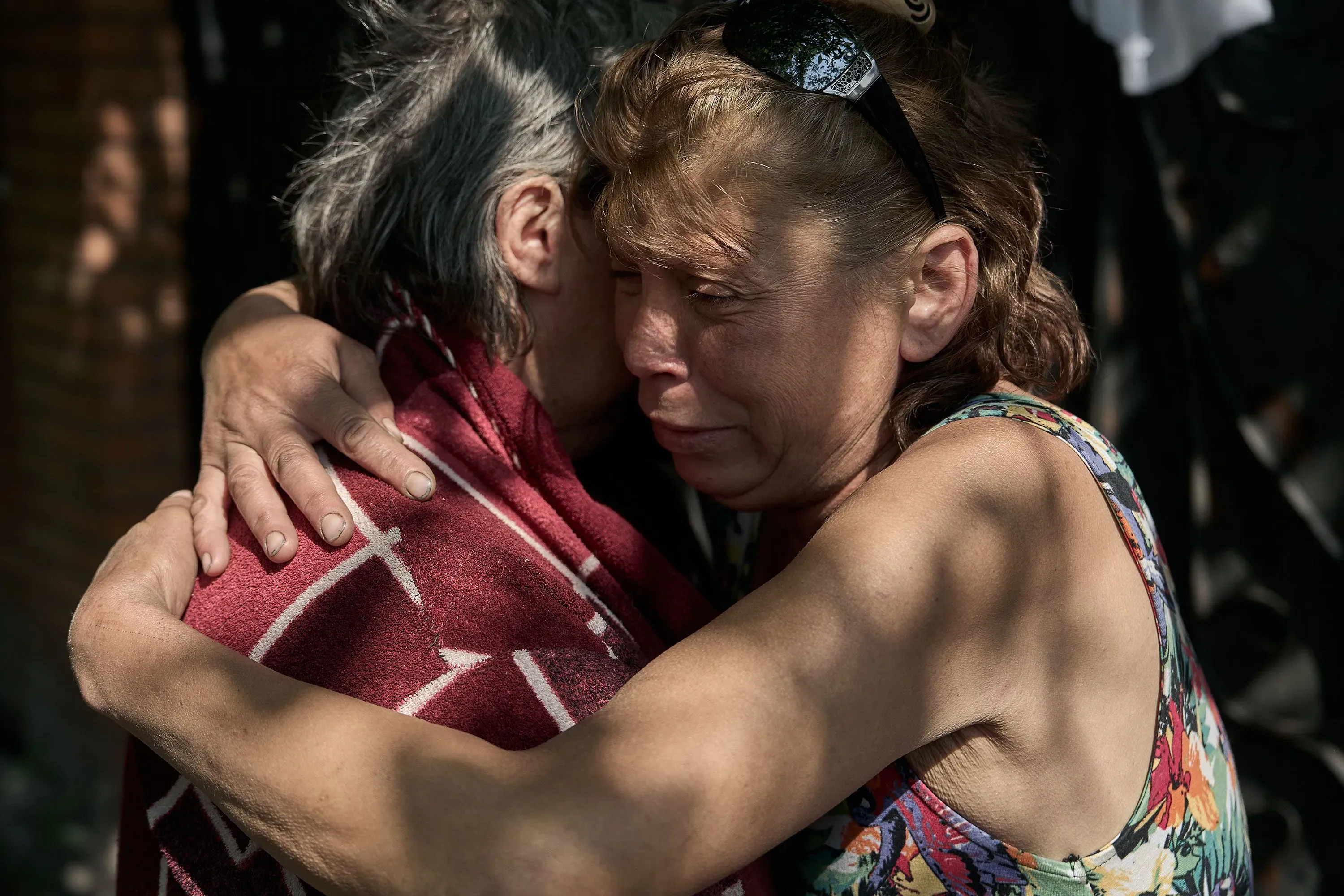 امرأتان تحتضنان بعضهما في لحظة عاطفية، تعبر عن الحزن والقلق خلال الصراع في بوكروفسك، أوكرانيا.