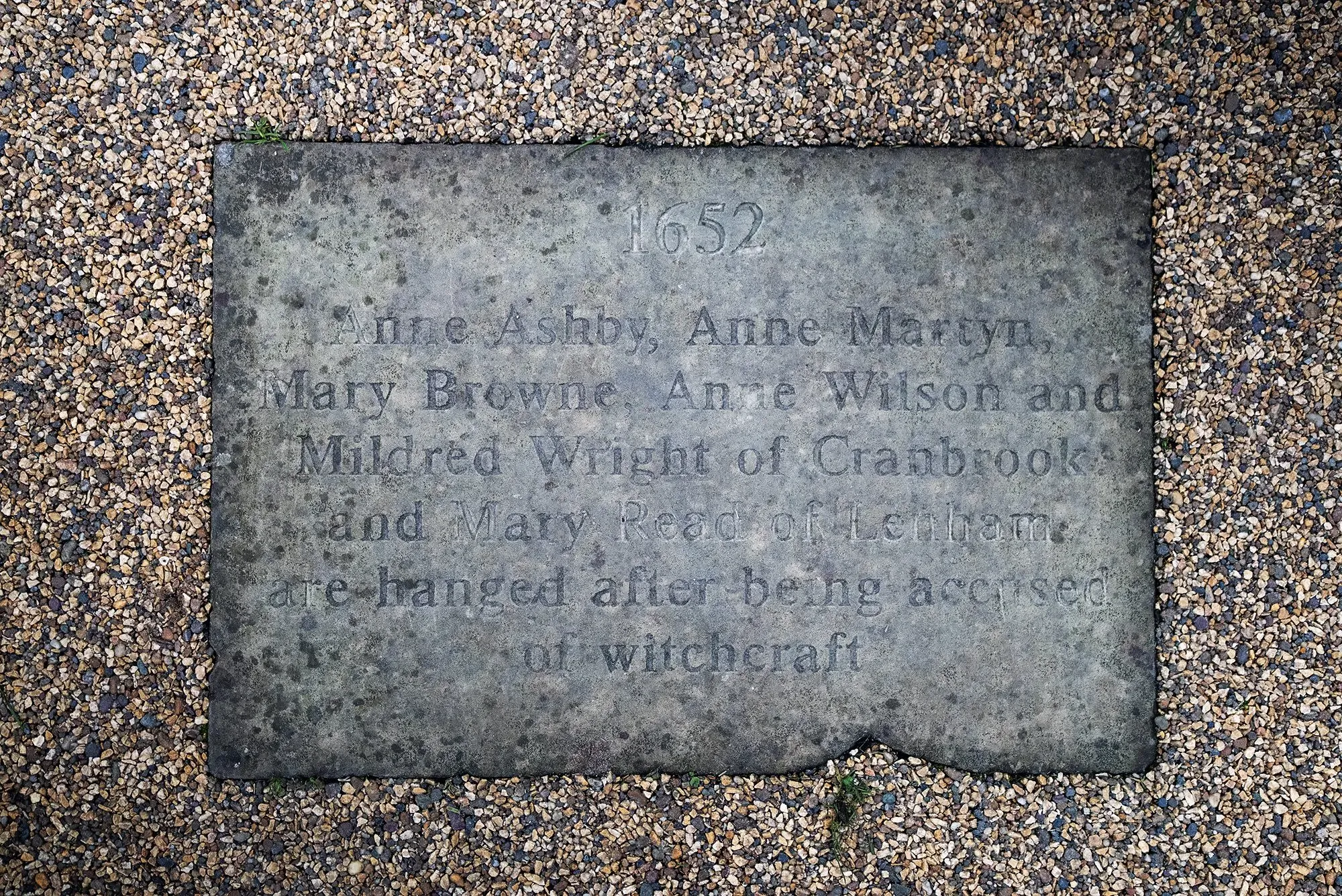 نقش حجري يخلد ذكرى النساء الخمس اللاتي أُعدمن بتهمة السحر في 1652، مدفون في حديقة بينندن هيث، جنوب إنجلترا.