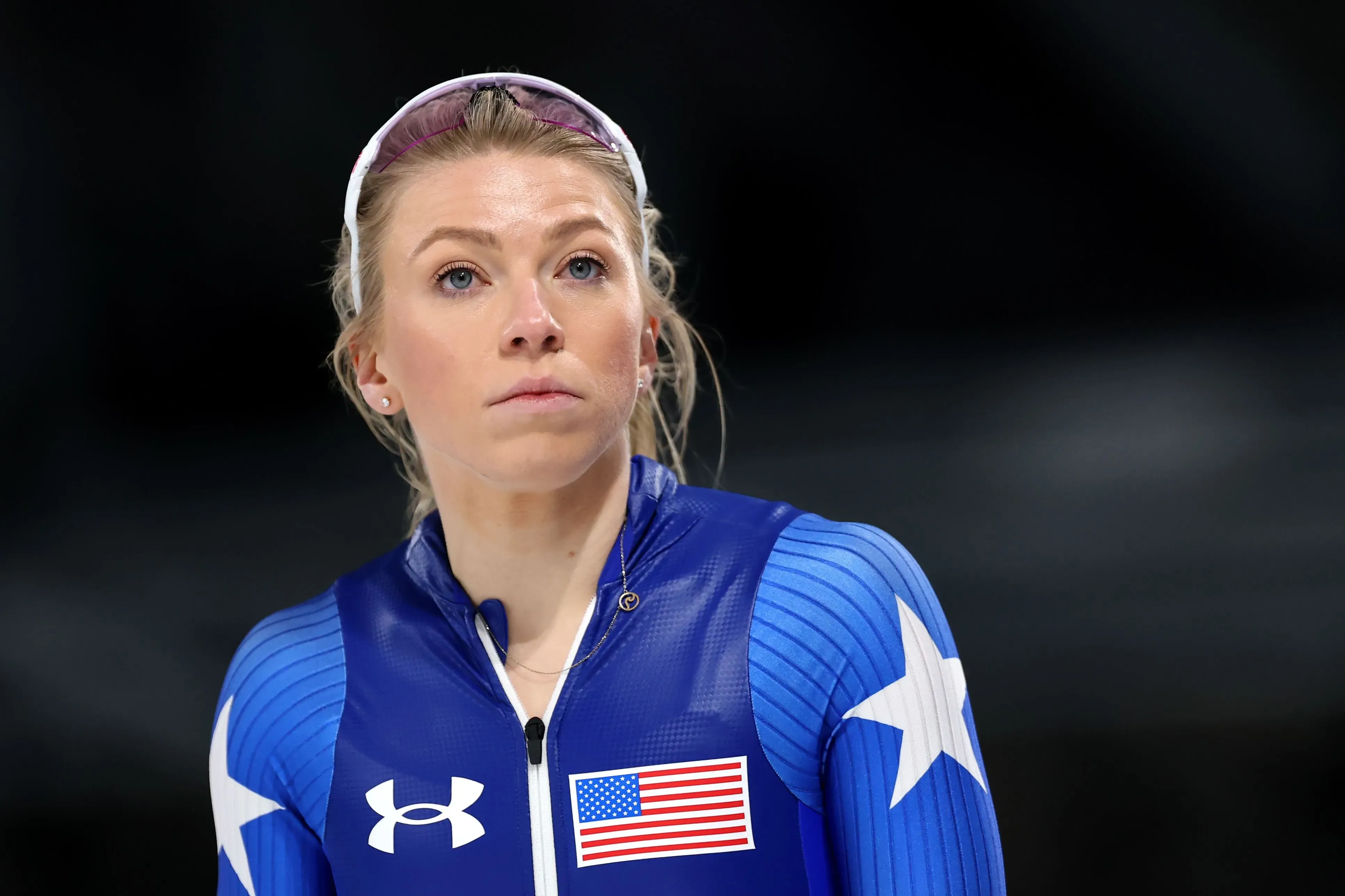 سارة وارن، متزلجة سريعة أمريكية، تظهر بملابس التزلج الزرقاء، تعبر عن تركيزها قبل المنافسة في الألعاب الأولمبية.