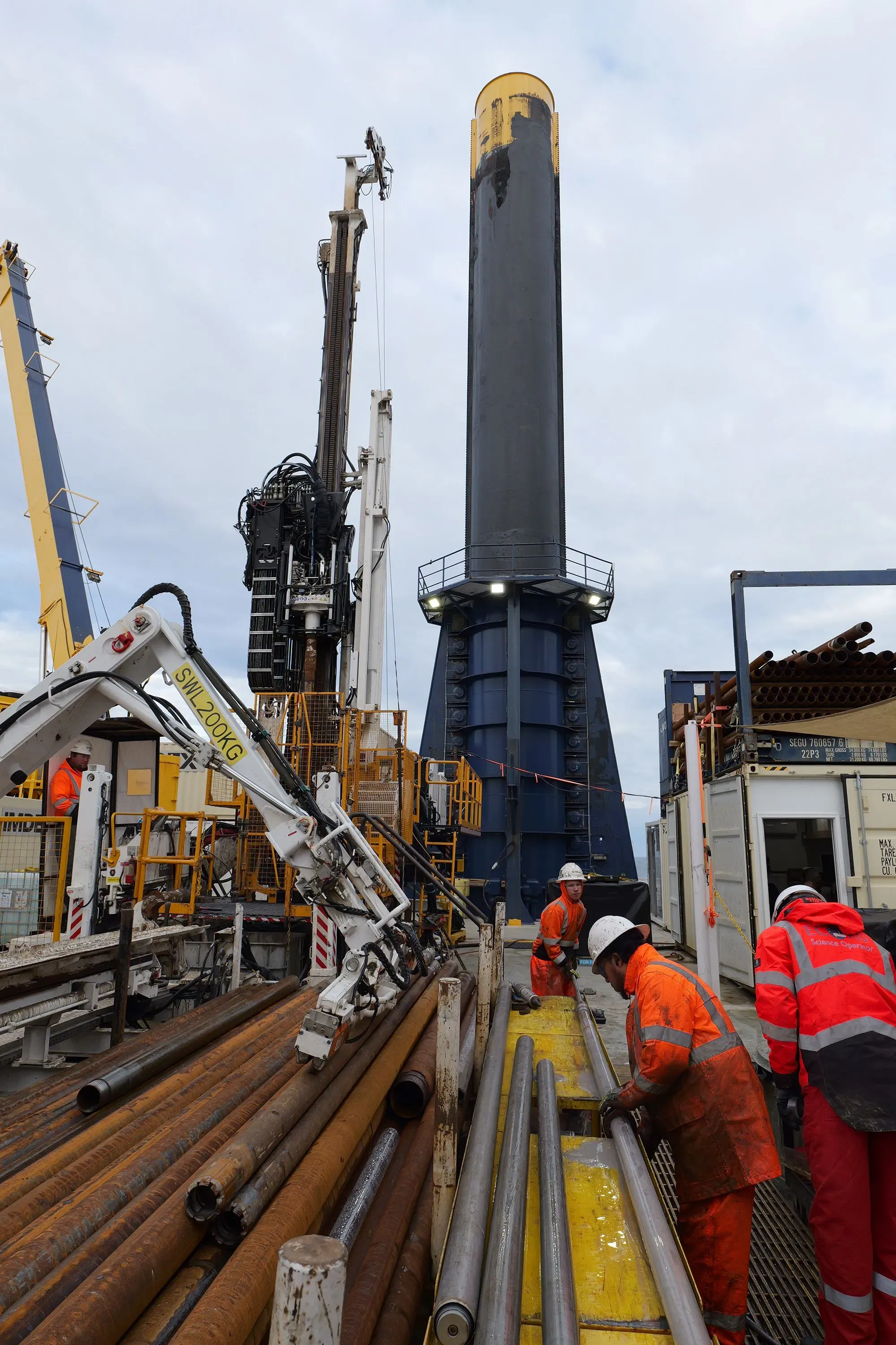 فريق من العلماء يعمل على سفينة حفر في المحيط الأطلسي، يستخرجون عينات من المياه العذبة تحت قاع البحر لدراستها.