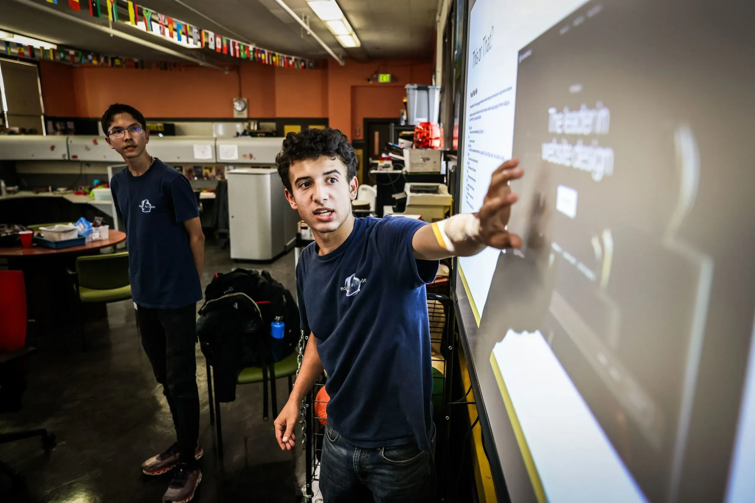 شاؤول يقدم درسًا في التكنولوجيا لمجموعة من كبار السن، مستخدمًا شاشة عرض تفاعلية، في إطار مبادرة "مود تو كود" التعليمية.