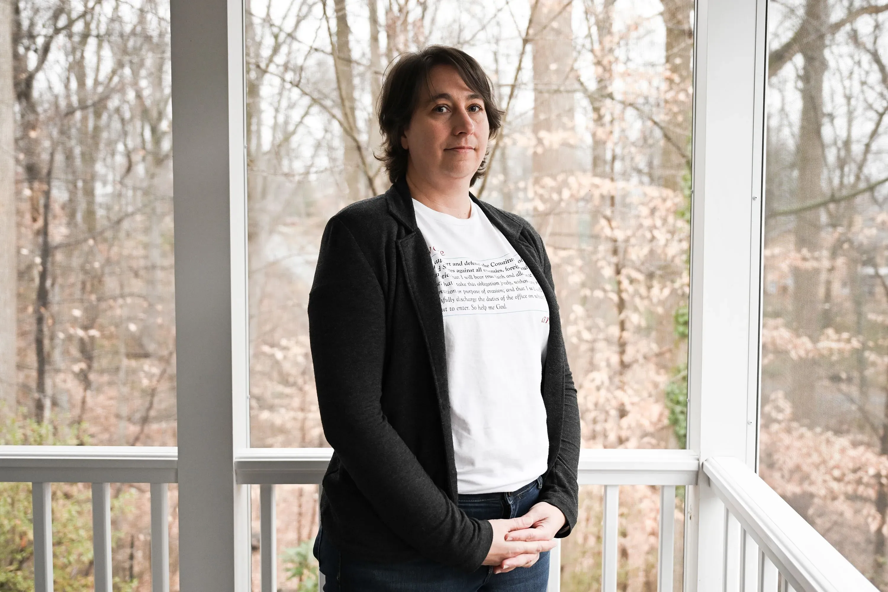 عالمة ترتدي قميصًا أبيض وتظهر في مكان مفتوح، تعبر عن قلقها بشأن تأثير إدارة ترامب على أبحاث الصحة العامة وتمويلها.