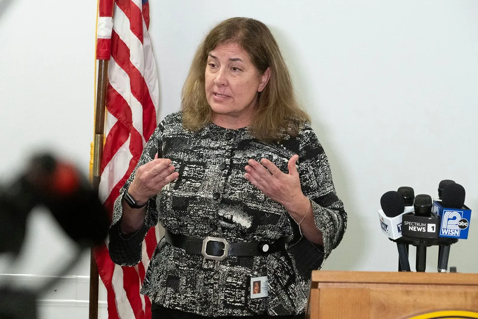 امرأة تتحدث في مؤتمر صحفي، مع وجود ميكروفونات وخلفية تتضمن علم الولايات المتحدة، تتعلق بالإفراج عن جيسير بعد فترة من الاحتجاز.