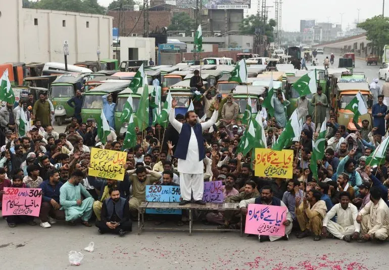 محتجون في باكستان يرفعون الأعلام ويهتفون خلال مظاهرة ضد ارتفاع أسعار الوقود، مع لافتات تعبر عن معاناتهم الاقتصادية.