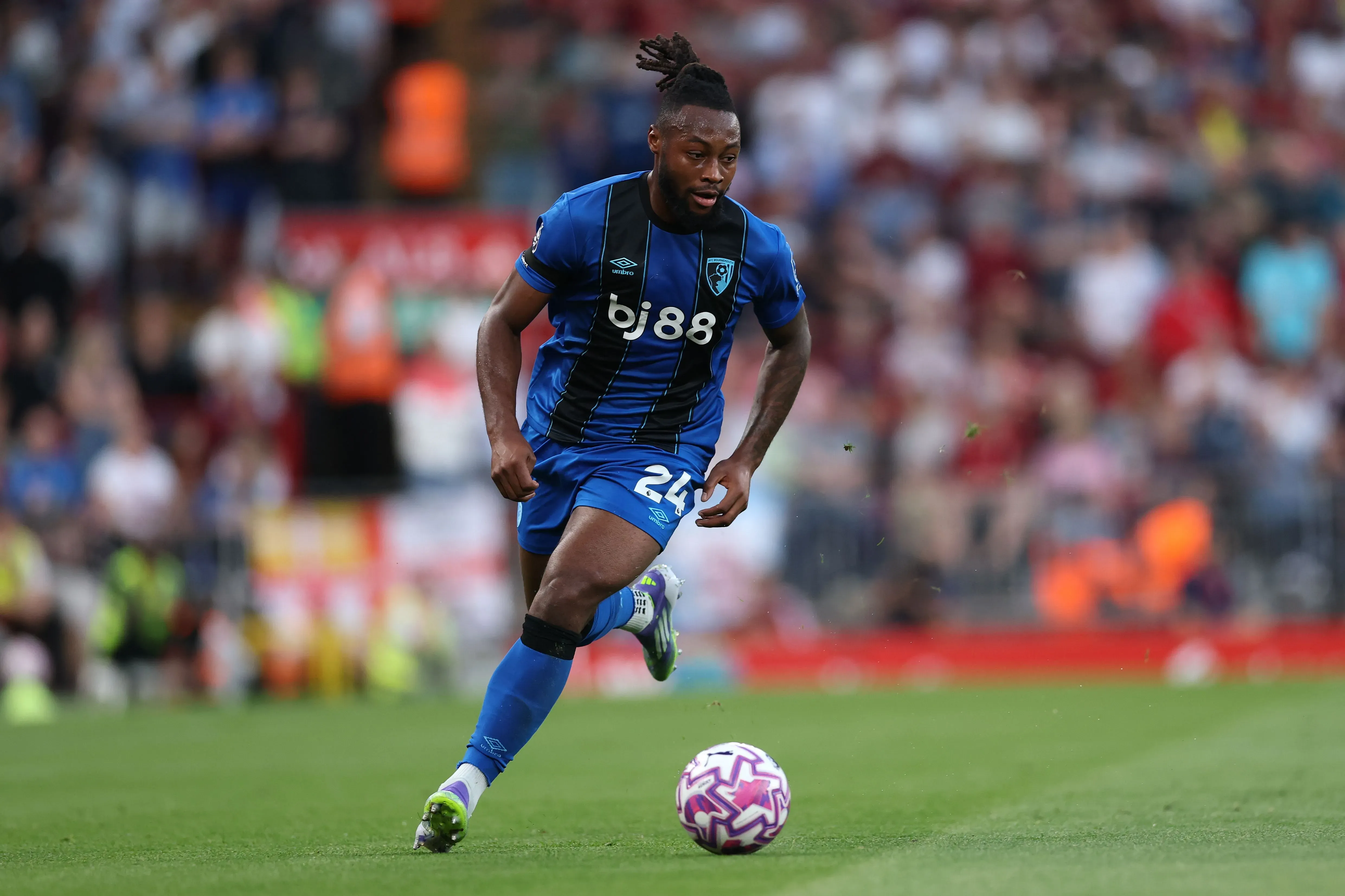 لاعب بورنموث أنطوان سيمينيو يجري بالكرة خلال مباراة، وسط جمهور متحمس، بعد حادثة إساءة عنصرية خلال المباراة.