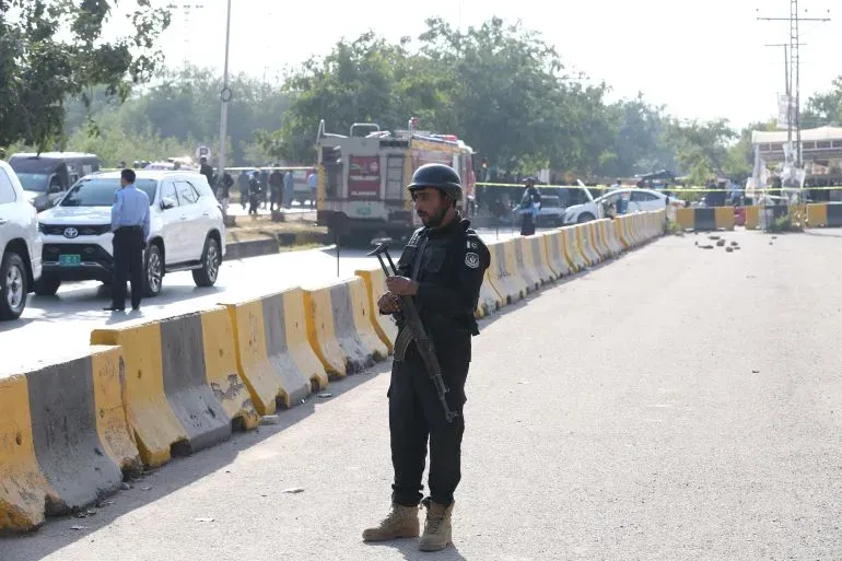 شرطي مسلح يقف بالقرب من موقع تفجير انتحاري خارج محكمة في إسلام أباد، حيث أسفر الهجوم عن مقتل 12 شخصًا وإصابة 27 آخرين.