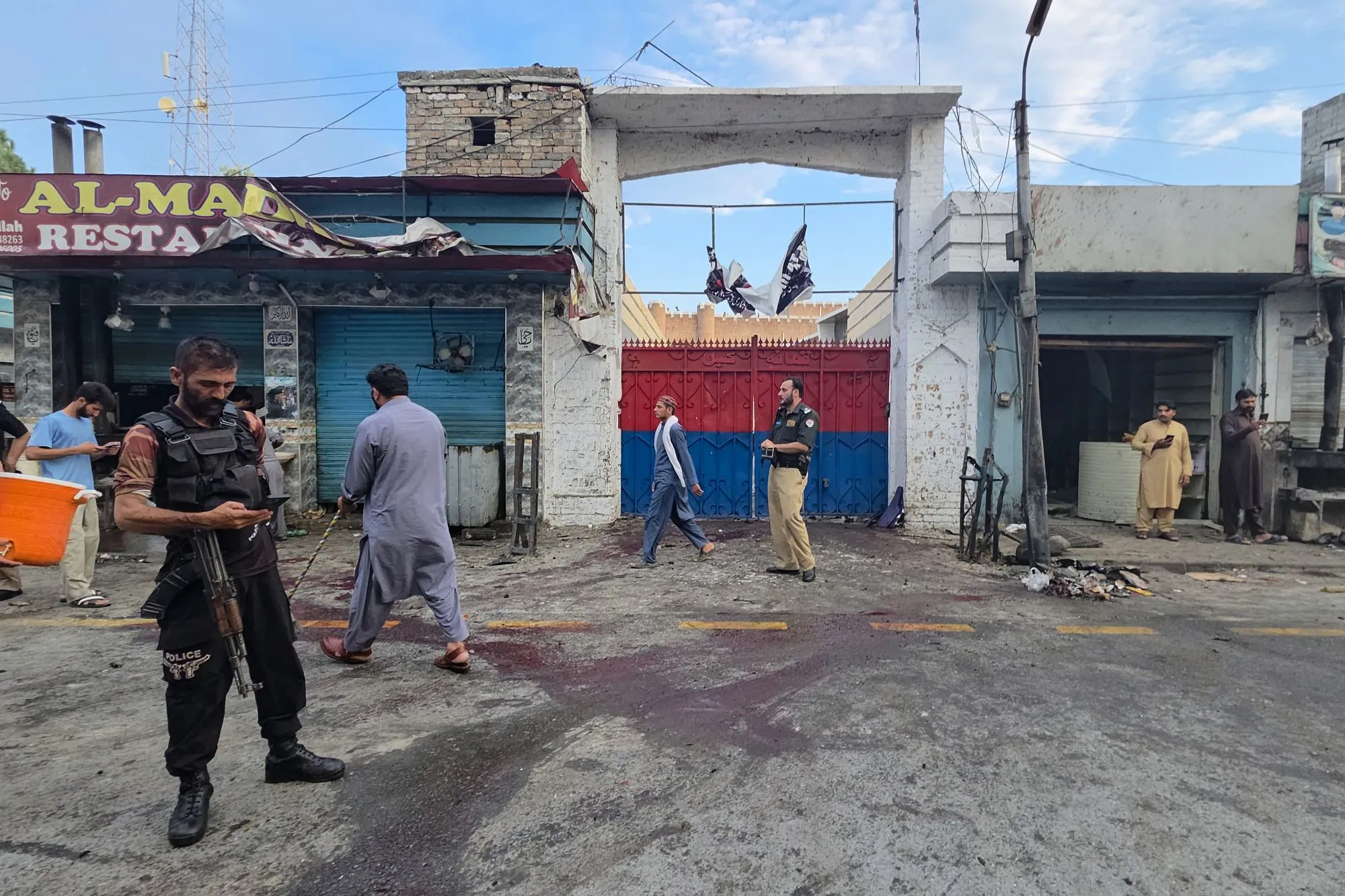 عناصر شرطة وسكان محليون يتفقدون موقع تفجير انتحاري في وادي سوات شمال غرب باكستان، وسط آثار دماء على الأرض، في سياق تصاعد الهجمات الإرهابية.