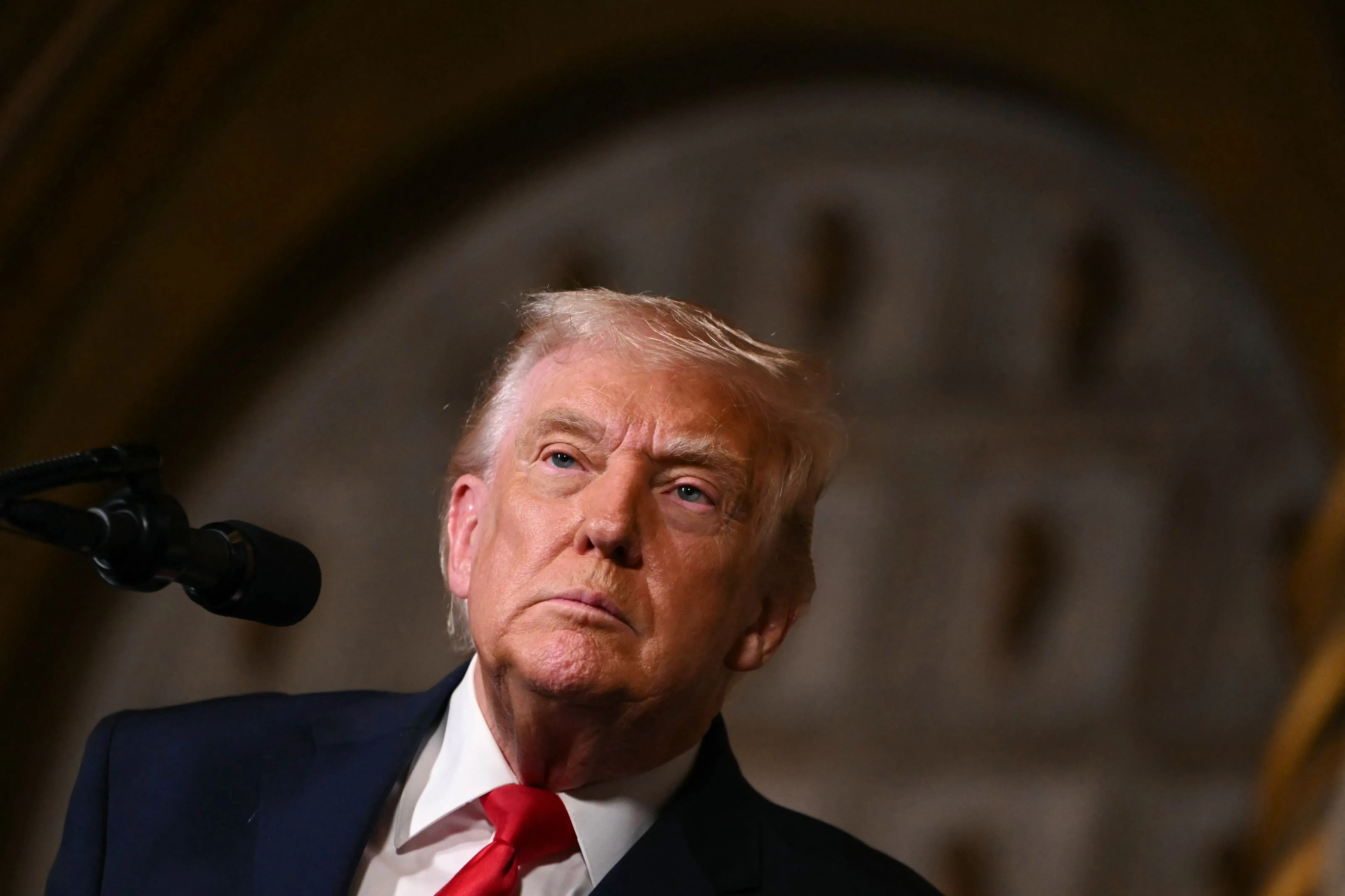 تعبير عن الرئيس ترامب أثناء حديثه، مع خلفية غير واضحة، يعكس التوتر السياسي حول استخدام الجيش في المدن الأمريكية.