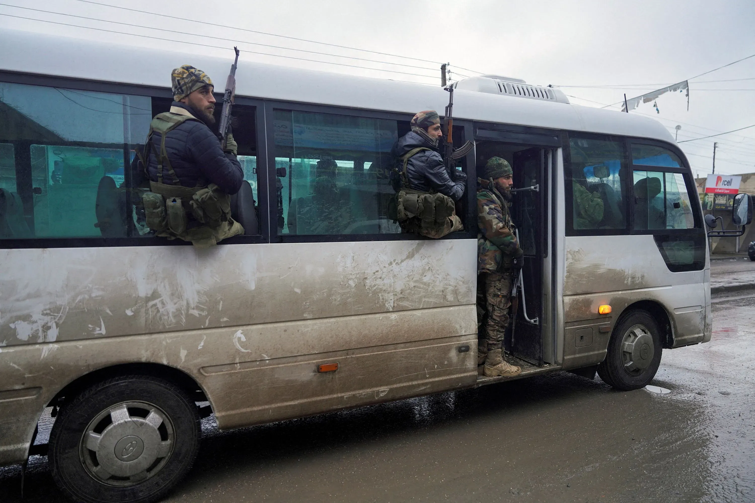 عناصر من الجيش السوري والميليشيات القبلية يستقلون حافلة أثناء انتشارهم في الرقة، بعد استعادة السيطرة على المدينة.