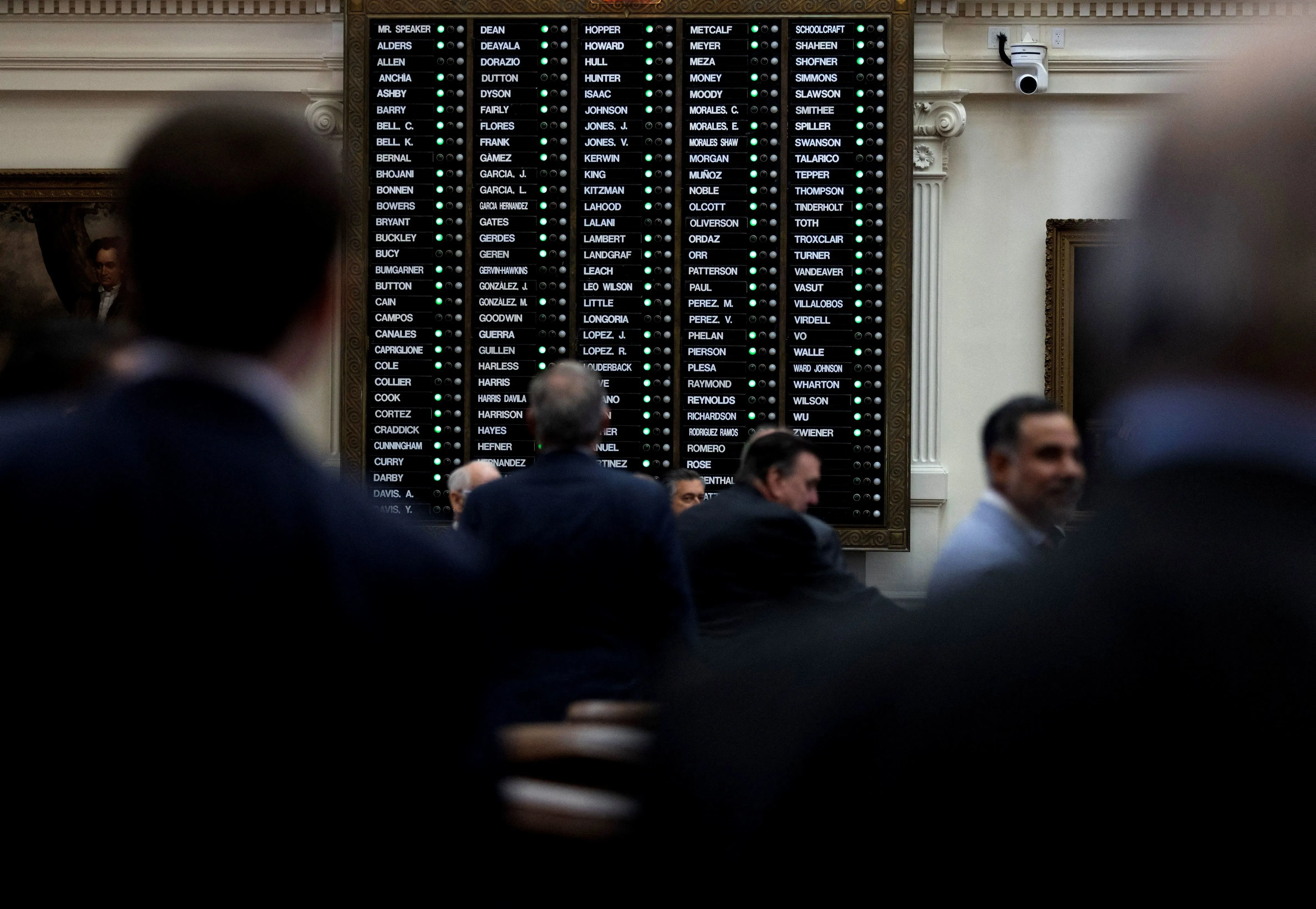 صورة تظهر مجلس النواب في تكساس أثناء التصويت على خرائط الكونغرس الجديدة، مع وجود الأعضاء والمعدات التقنية في الخلفية.