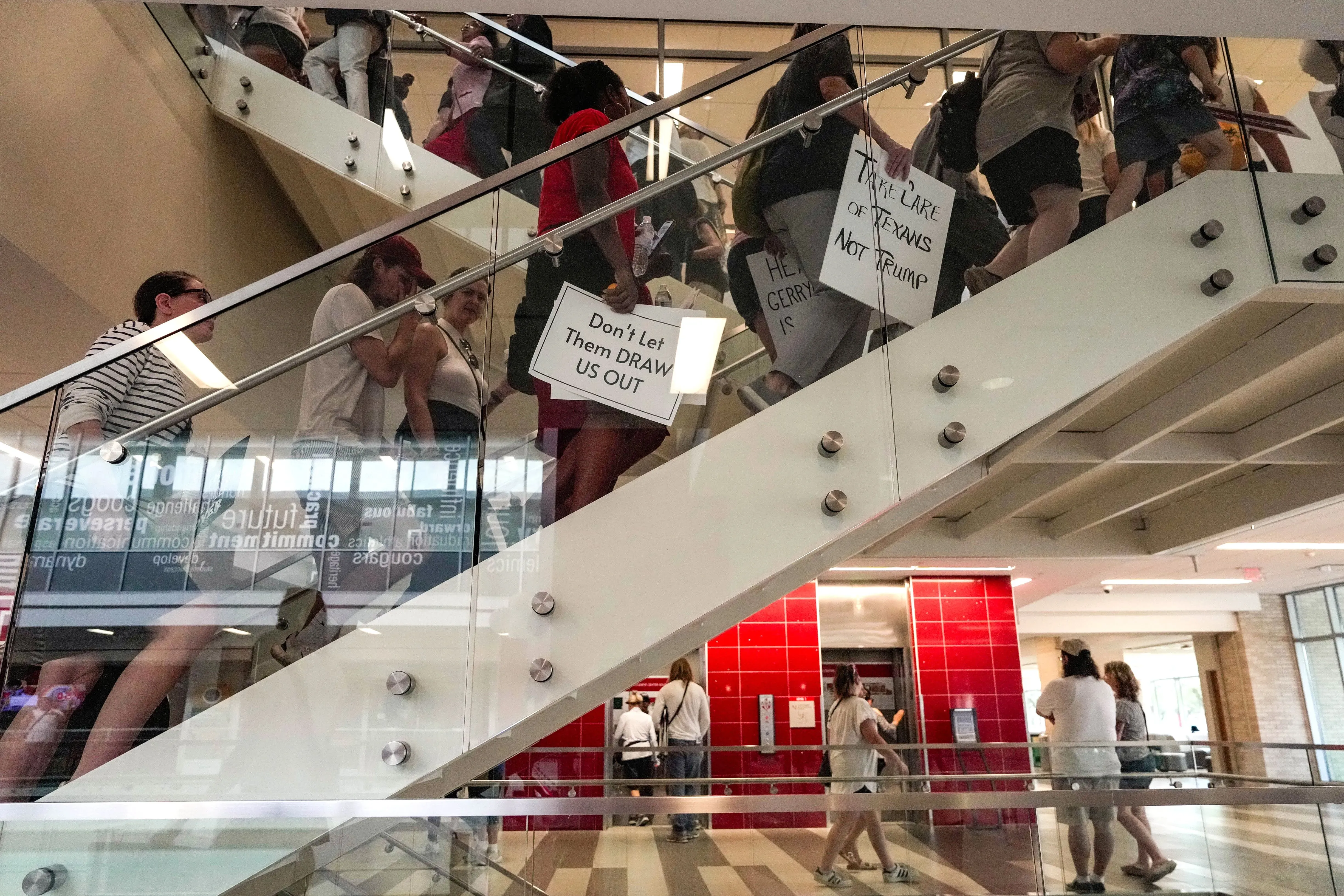 تجمع حشود من المحتجين في مبنى، يحملون لافتات تعبر عن معارضتهم لخريطة الكونغرس الجديدة في تكساس، مطالبين بحماية حقوق الناخبين.