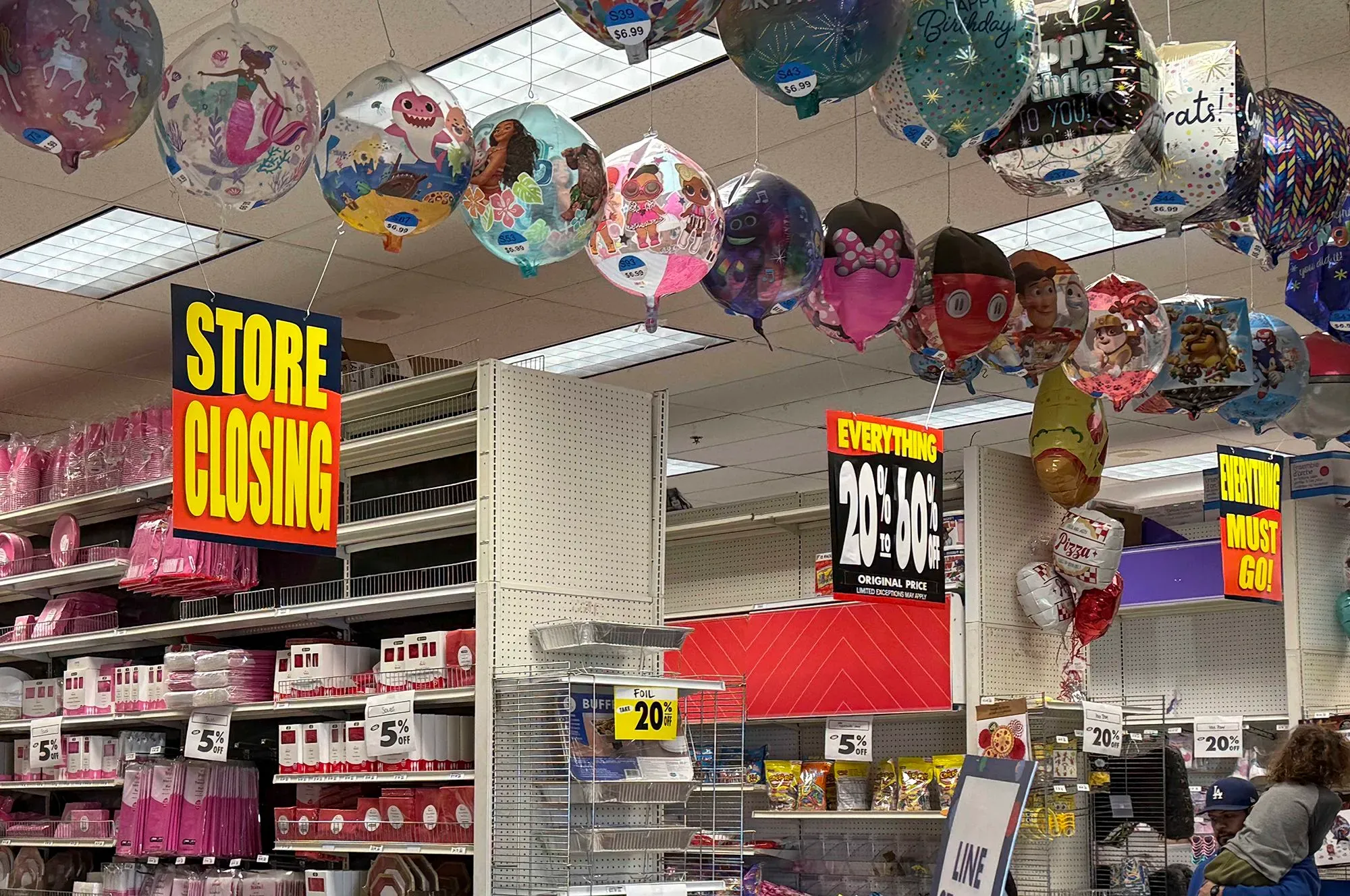 متجر مغلق مع لافتات تشير إلى إغلاقه، وديكورات احتفالية مثل البالونات، تعكس تراجع سلاسل التجزئة في عام 2025.