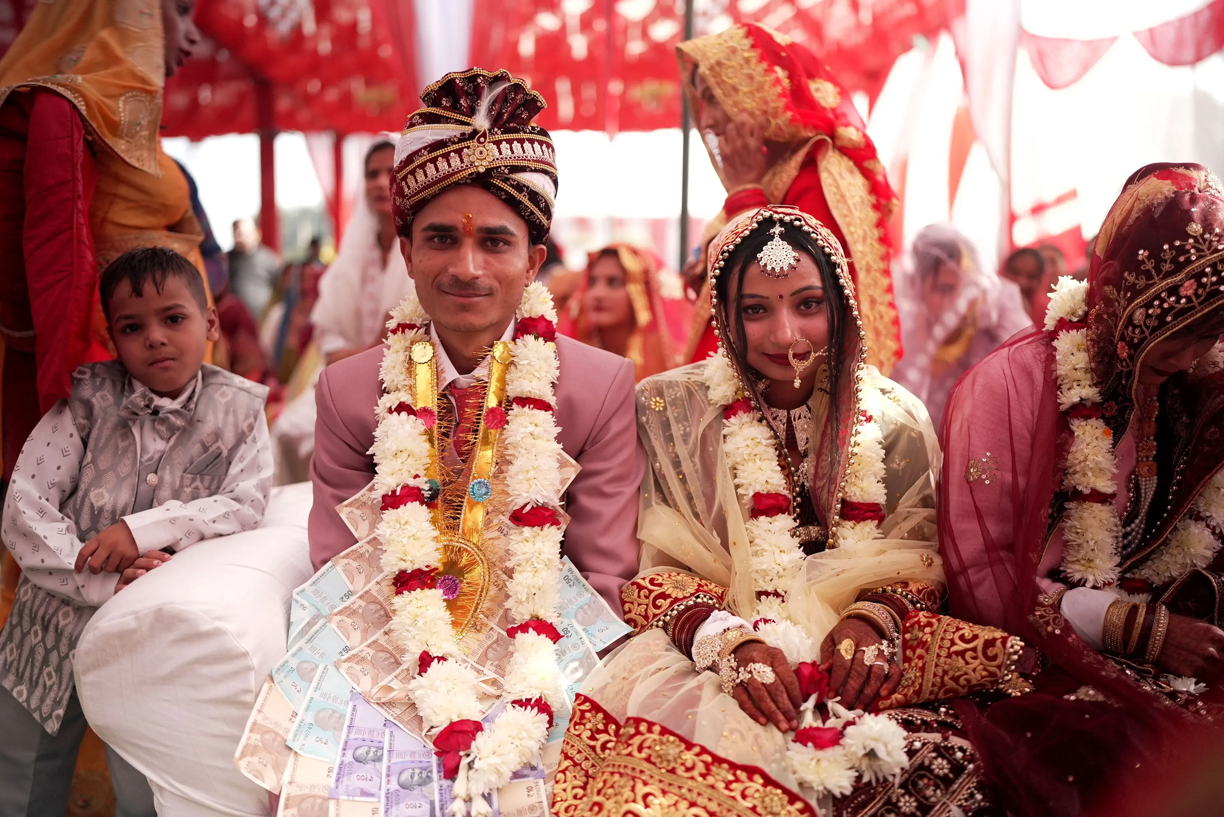 حفل زفاف تقليدي في الهند يظهر العروس والعريس مرتديين ملابس مزينة، مع زهور وديكور فاخر، وسط أجواء احتفالية.