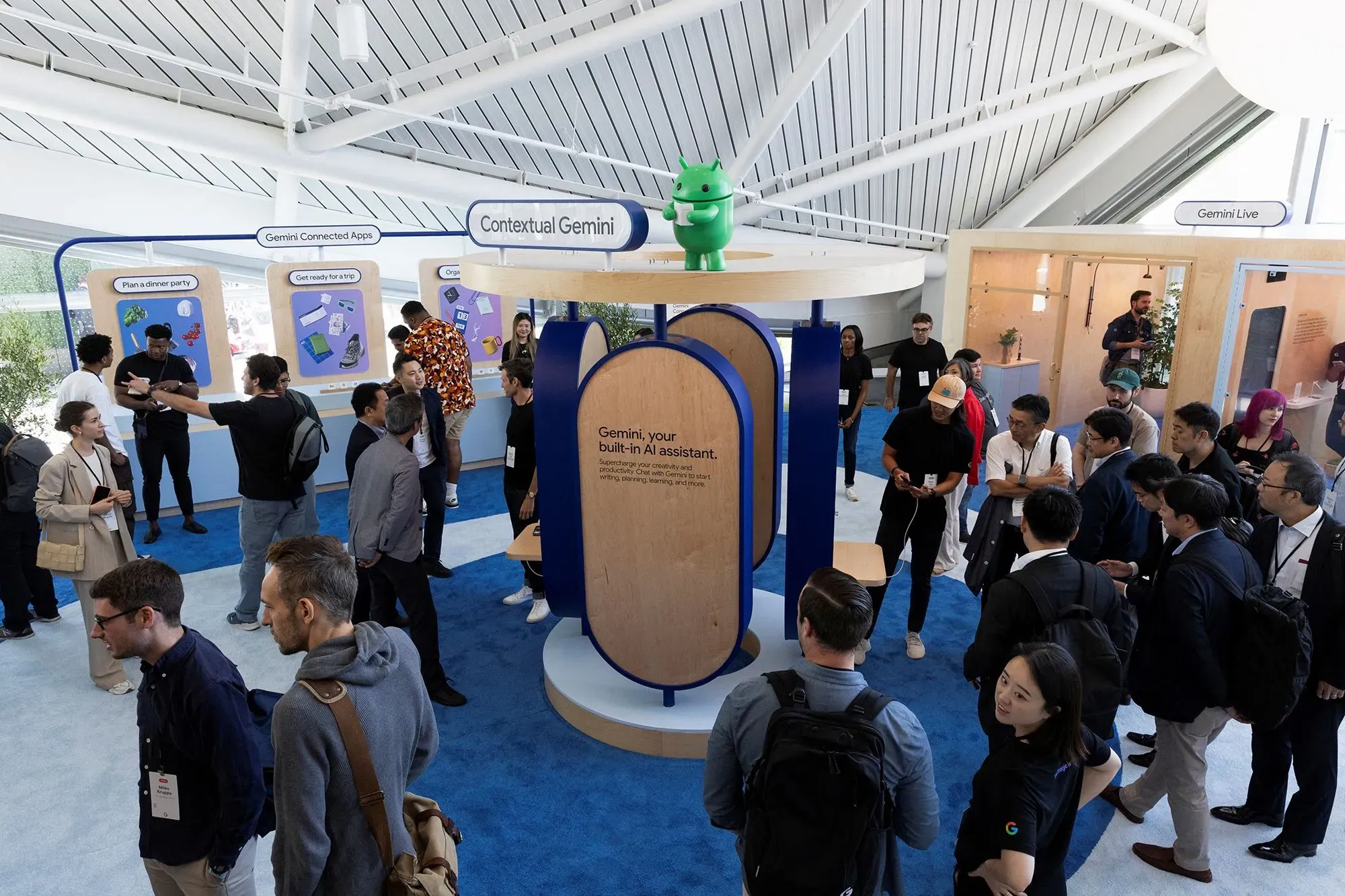 تجمع حاشد حول منصة عرض تطبيق Gemini 3 من Google، مع تفاعل الزوار واستعراض الميزات الجديدة للذكاء الاصطناعي.