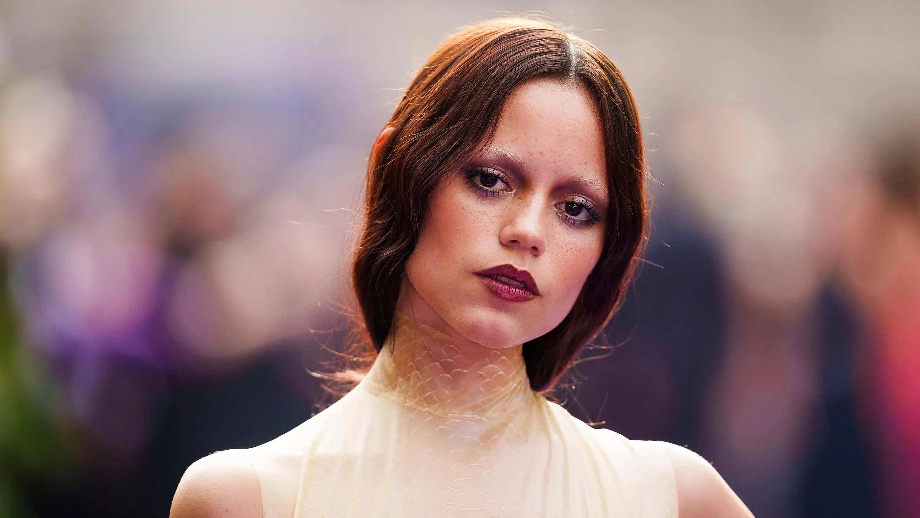 جينا أورتيغا تظهر بإطلالة "الفتاة المتعبة" مع عيون مظللة وشفتين أرجوانيتين، تعبيرها يعكس جماليات الجيل Z الحديثة.