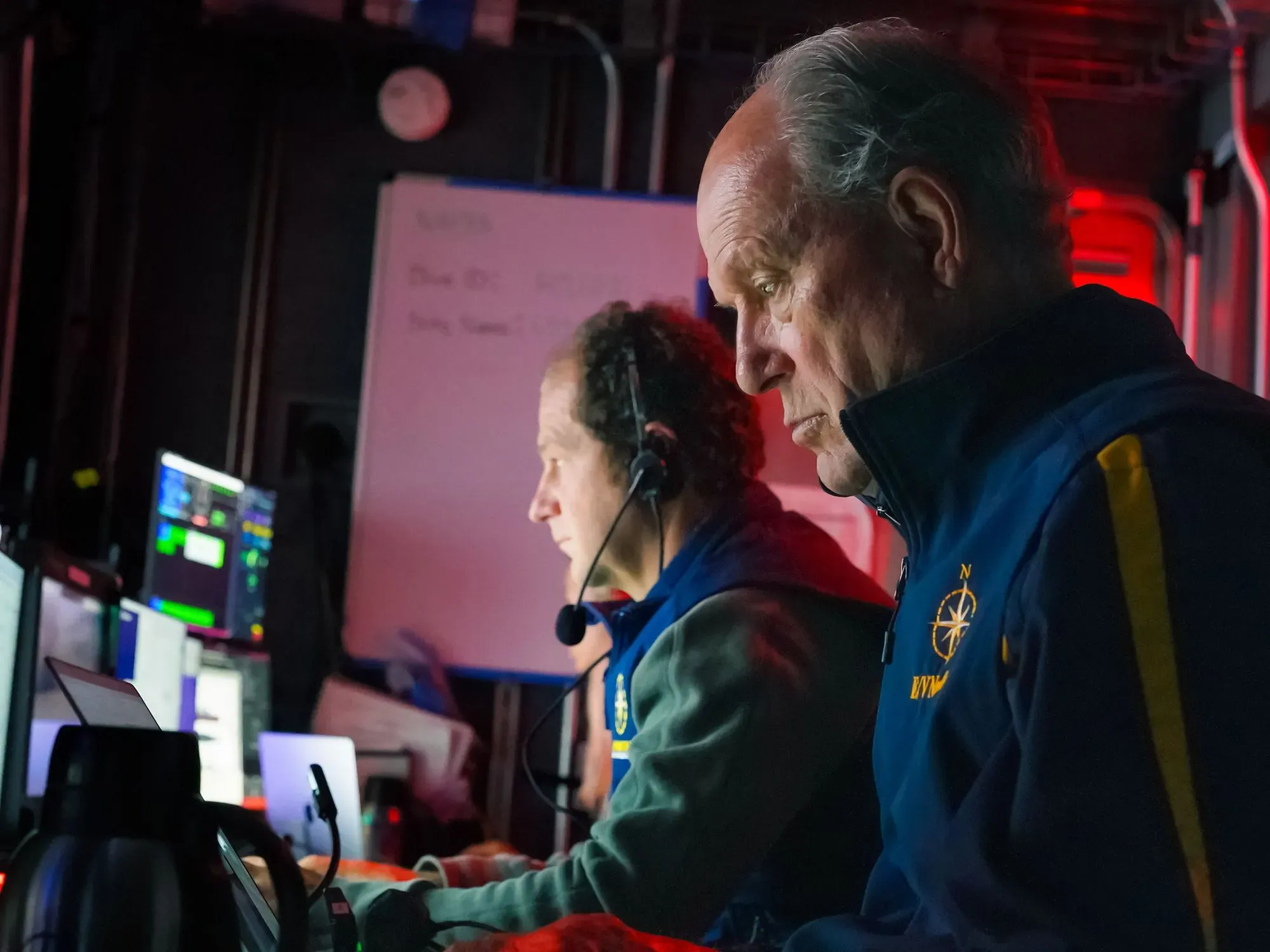 فريق البحث يعمل في مركز قيادة سفينة الأبحاث، مع شاشات تعرض معلومات حول حطام السفينة تيتانيك.