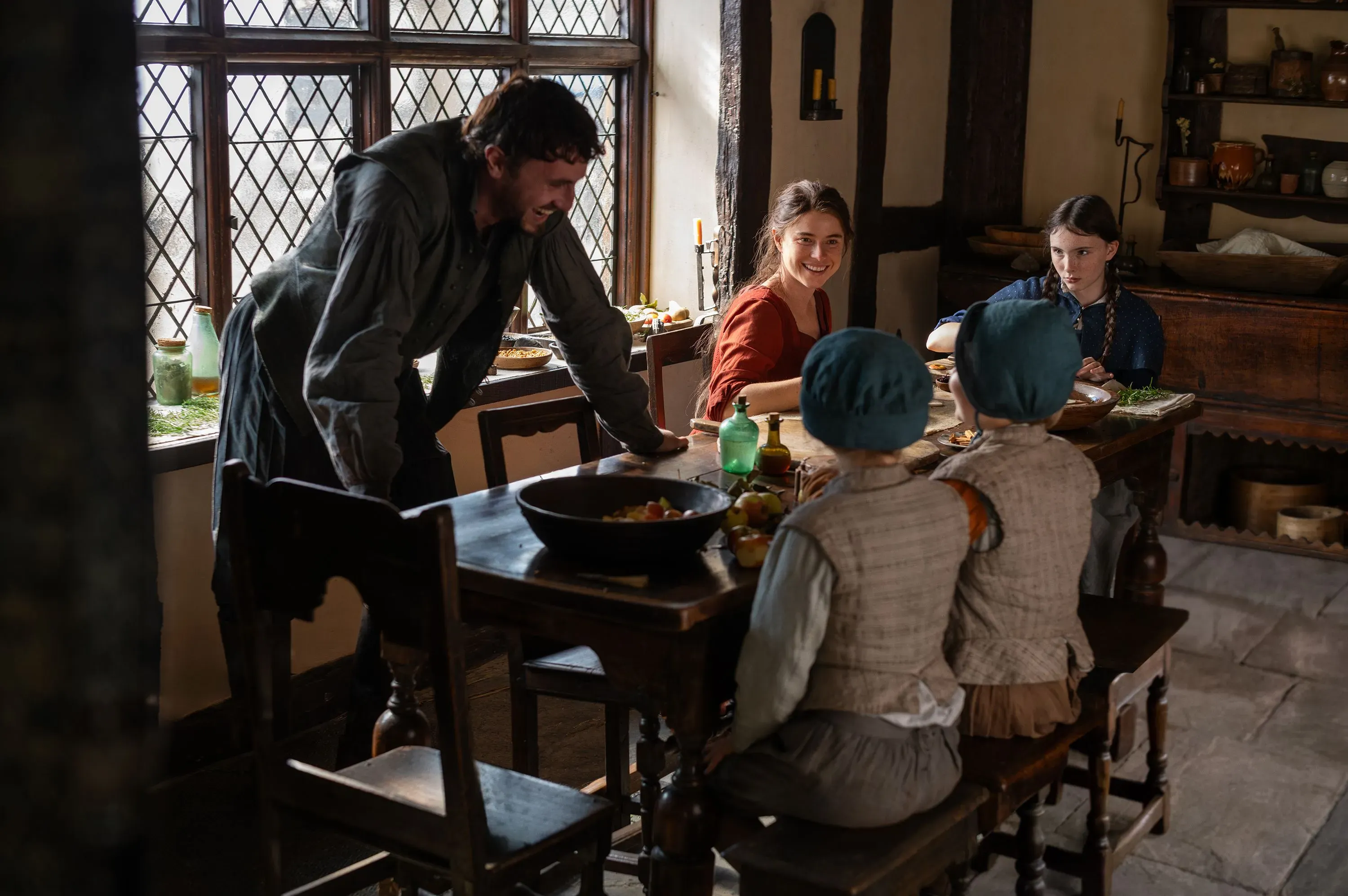 مشهد من فيلم "هامنت" يظهر عائلة تتناول الطعام في مطبخ تقليدي، مع التركيز على التفاعل بين الشخصيات.