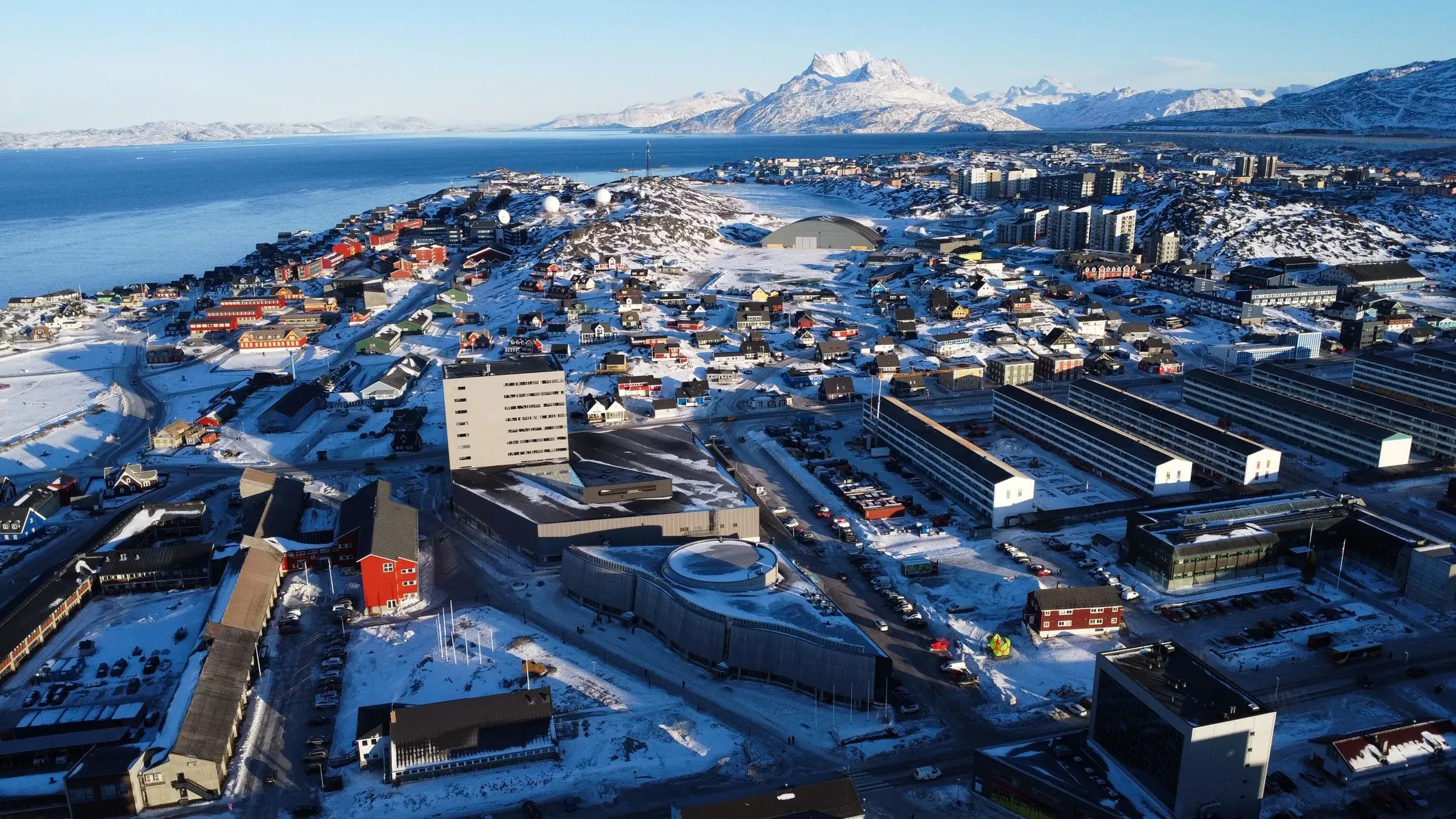 منظر جوي لمدينة مينيابوليس المغطاة بالثلوج، يظهر المباني السكنية والتجارية على خلفية البحر والجبال. تعكس الصورة الأجواء القاسية في يناير.