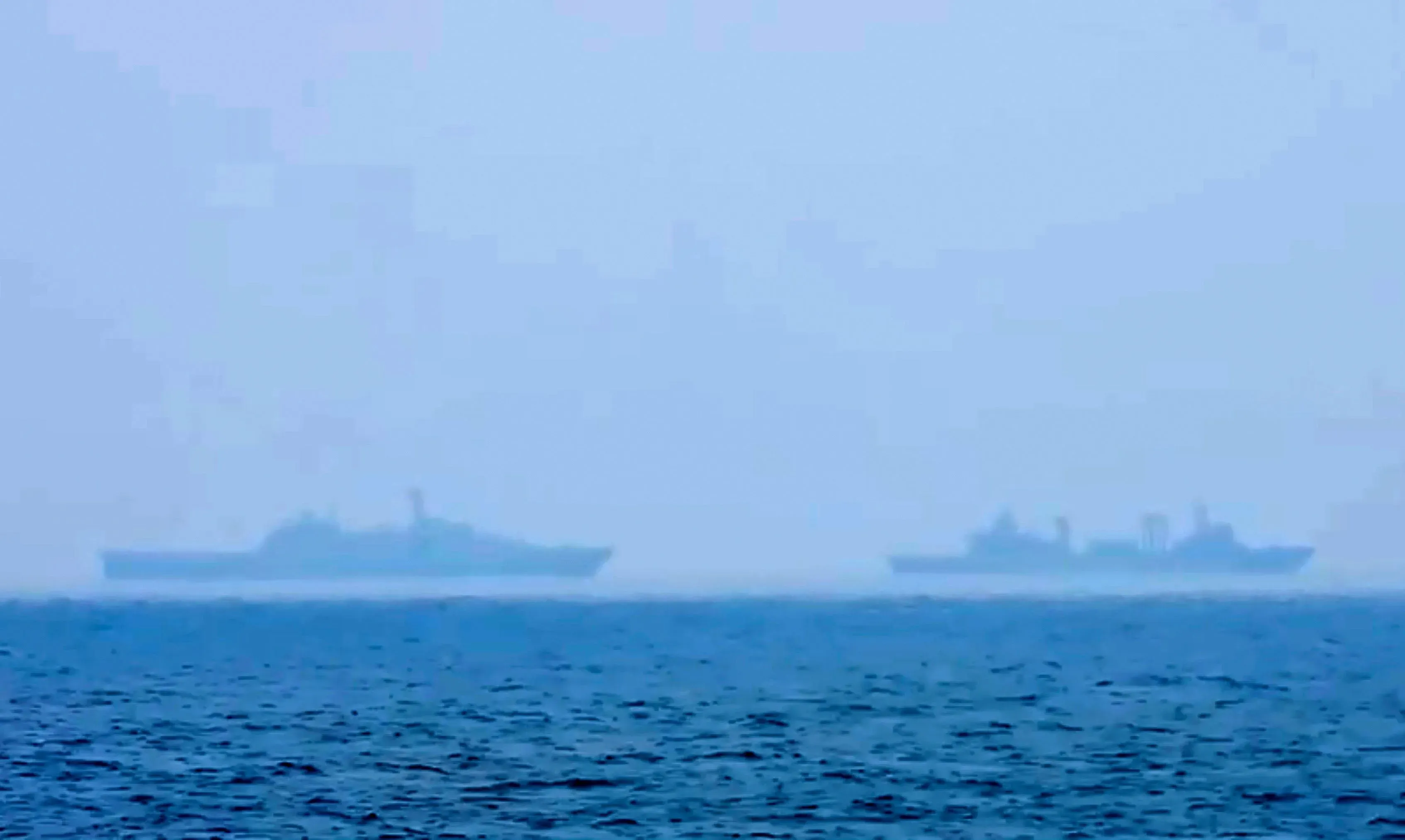 سفينتان عسكريتان في بحر ضبابي، تعكسان التوترات المتزايدة بين اليابان والصين حول تايوان والتهديدات العسكرية المحتملة.