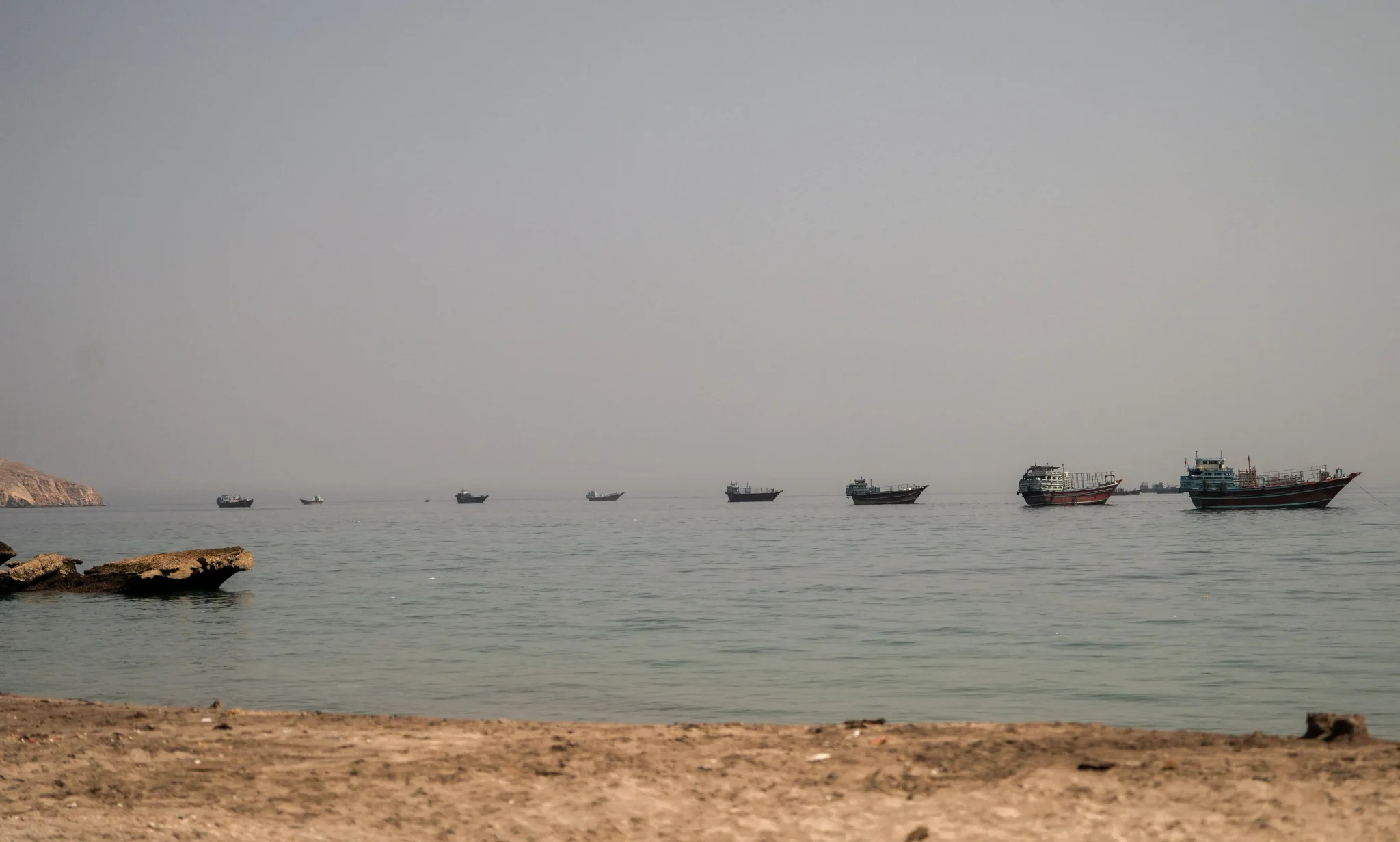 تظهر الصورة مجموعة من السفن الراسية في الخليج العربي، مما يعكس تأثير إغلاق مضيق هرمز على حركة الملاحة البحرية.