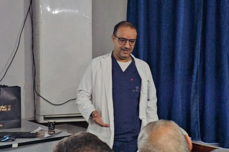 طبيب يتحدث في مركز طبي بتعز، حيث يُجري عمليات قلب للأطفال. يُظهر التزام الفريق الطبي بتقديم رعاية صحية متقدمة رغم الظروف الصعبة.