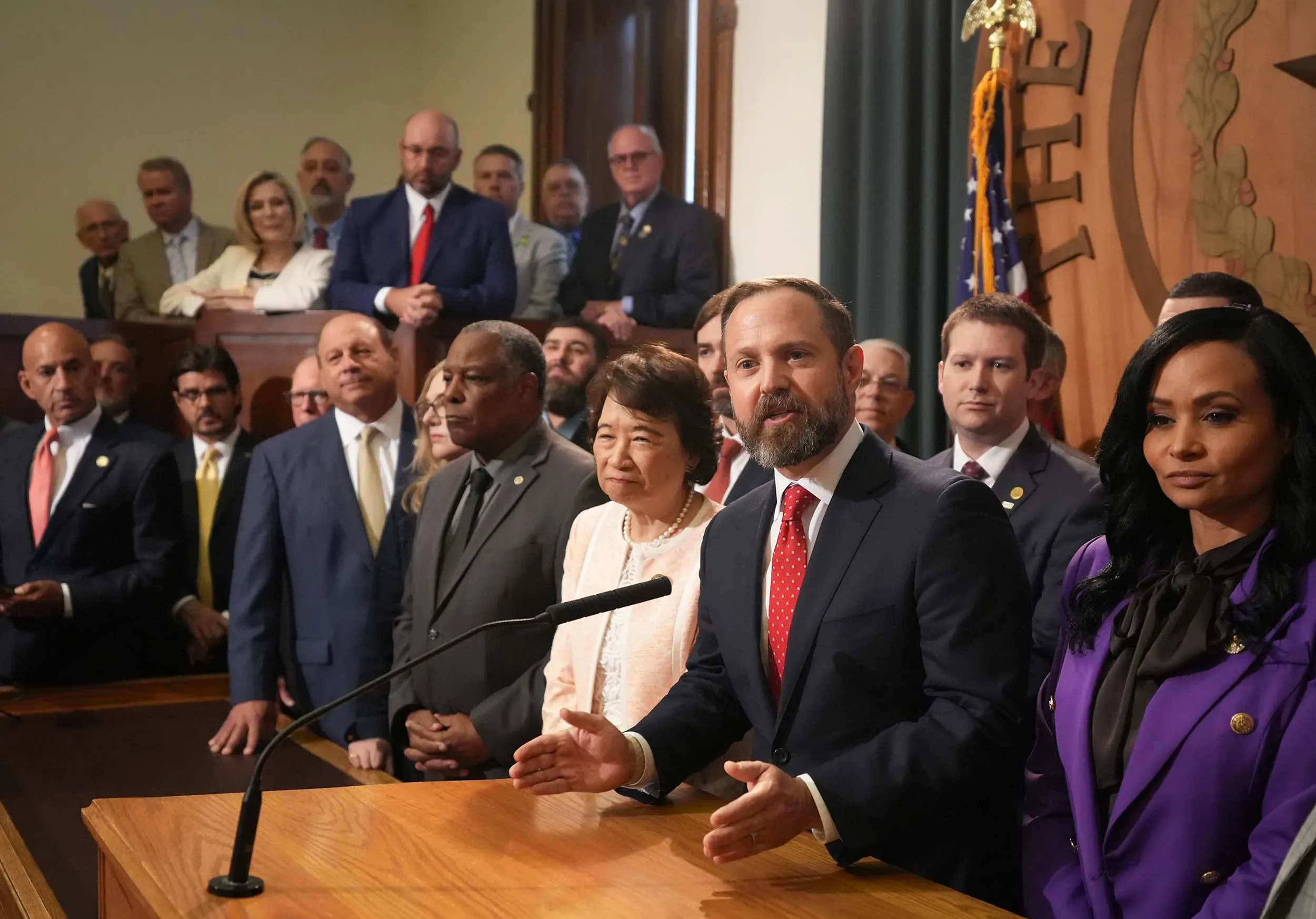 اجتماع لمشرعي تكساس في مجلس النواب، حيث يتحدث أحدهم أمام الميكروفون، مع وجود عدد من الأعضاء خلفه، في سياق مناقشة إعادة تقسيم الدوائر الانتخابية.