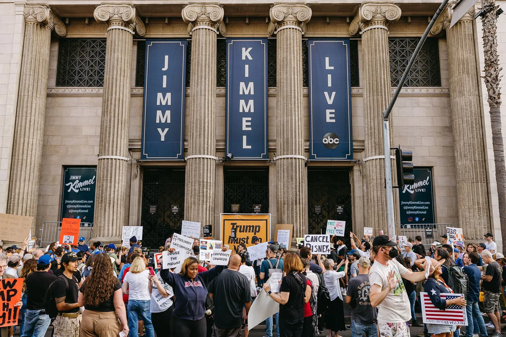 احتجاجات خارج استوديو "جيمي كيميل لايف" في لوس أنجلوس، حيث يحمل المتظاهرون لافتات تدعو إلى إلغاء البرنامج والتعبير عن آراء سياسية.