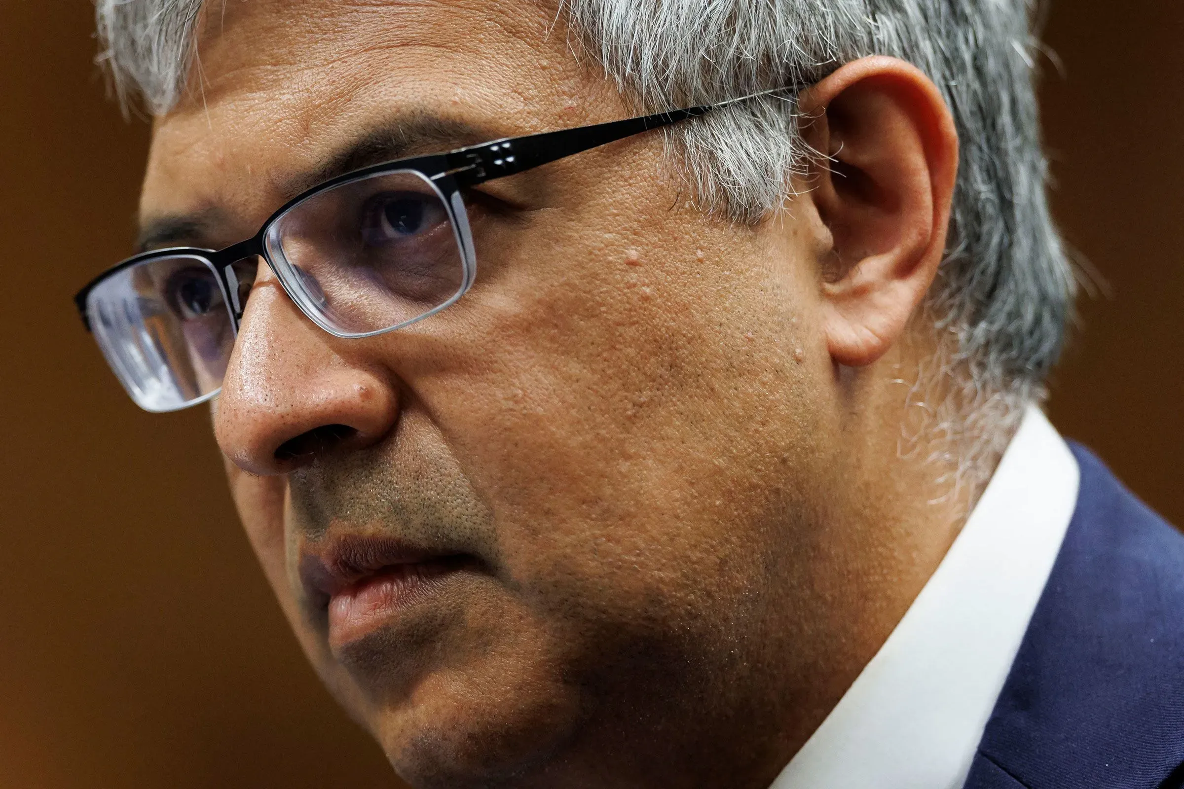 صورة لجاي بهاتاشاريا، أستاذ في جامعة ستانفورد، يظهر فيها بملامح جدية وهو يرتدي نظارات، تعكس تأثيره المتزايد في سياسة الصحة العامة الأمريكية.