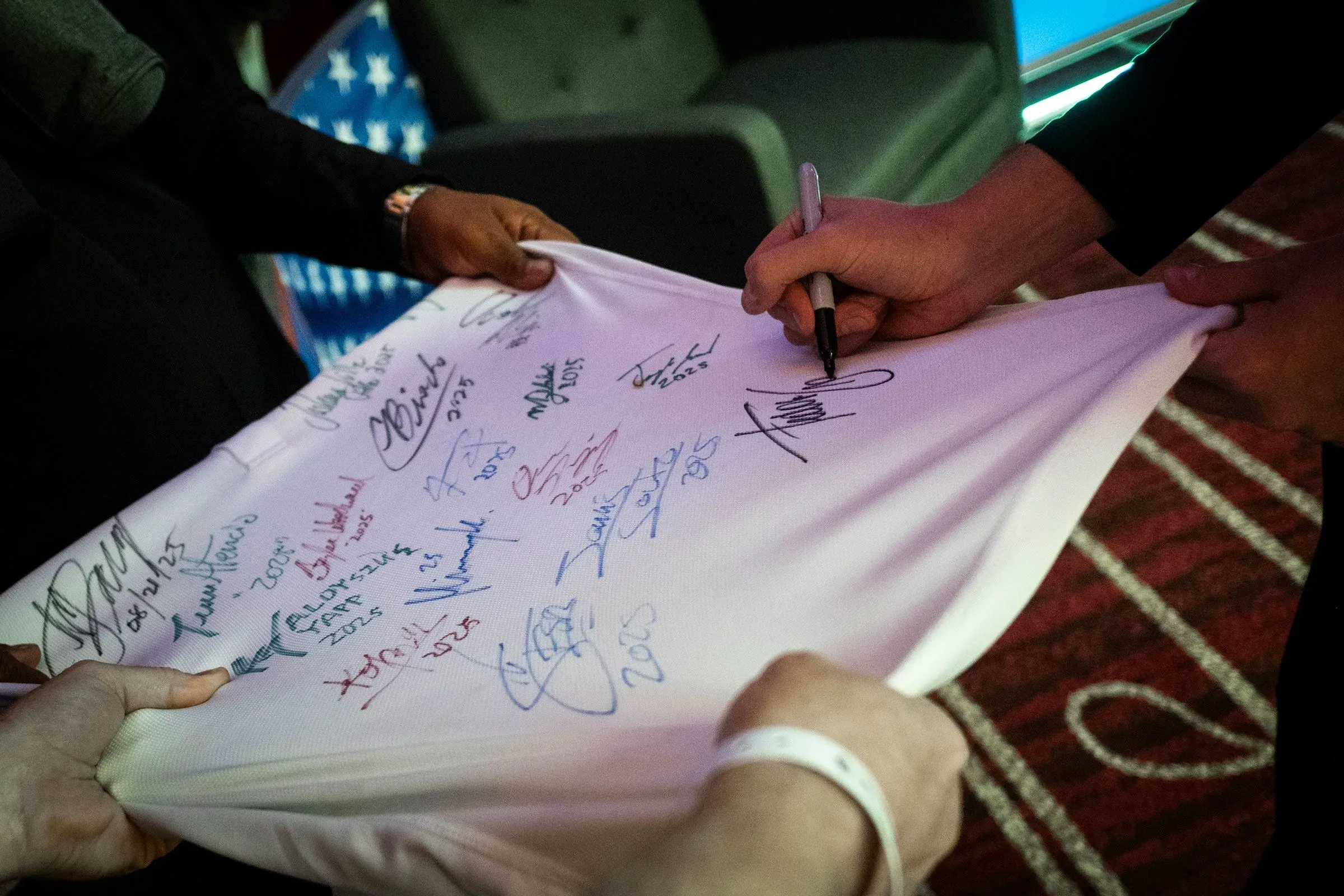 غورست يوقع على قميص أبيض بعد فوزه في بطولة الولايات المتحدة المفتوحة، محاطاً بتوقيعات لاعبين آخرين، مما يعكس نجاحه في البلياردو.