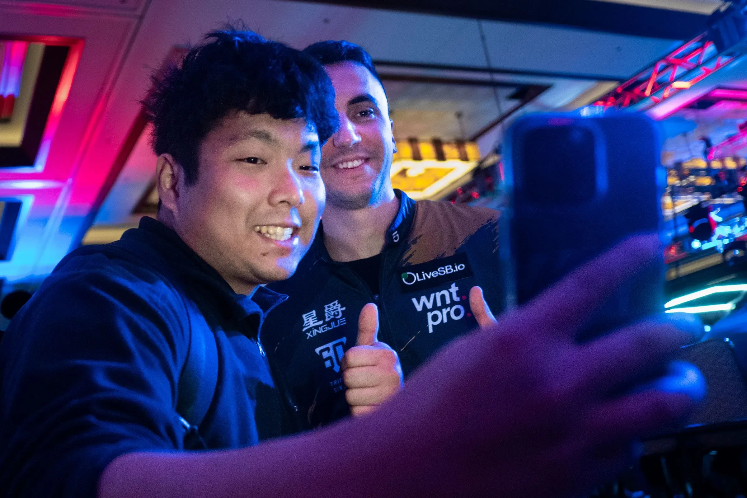 غورست وبطل آخر يلتقطان صورة سيلفي بعد مباراة في بطولة الولايات المتحدة المفتوحة للبلياردو، وسط أجواء احتفالية.