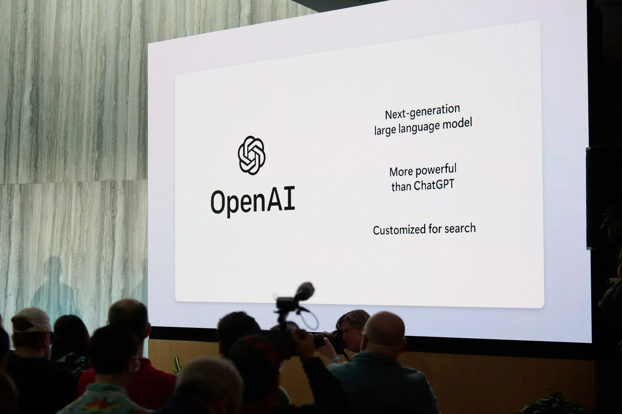 شاشة عرض تقدم شعار OpenAI ونموذج لغة الجيل القادم أقوى من ChatGPT، في مؤتمر يسلط الضوء على تطور الذكاء الاصطناعي التحويلي.