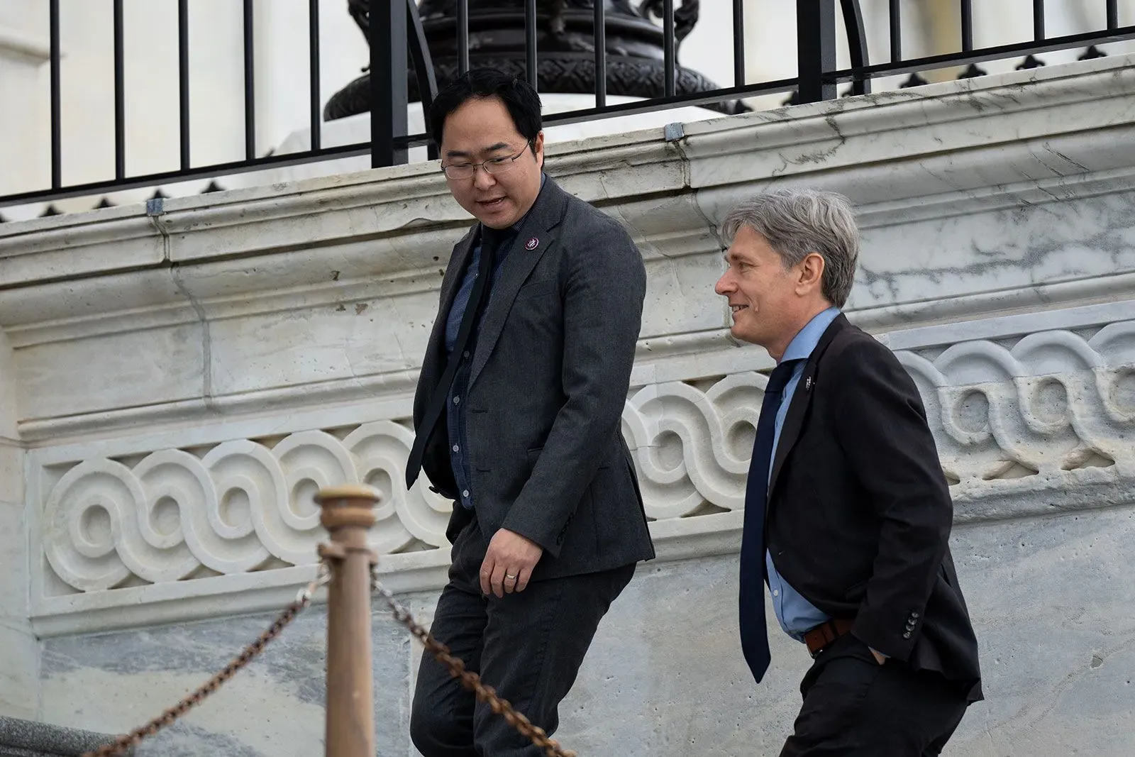 مشرعان سابقان يتحدثان أثناء نزولهما من الدرج في مبنى الكونغرس، مع التركيز على القضايا السياسية الحالية والتحديات الانتخابية.