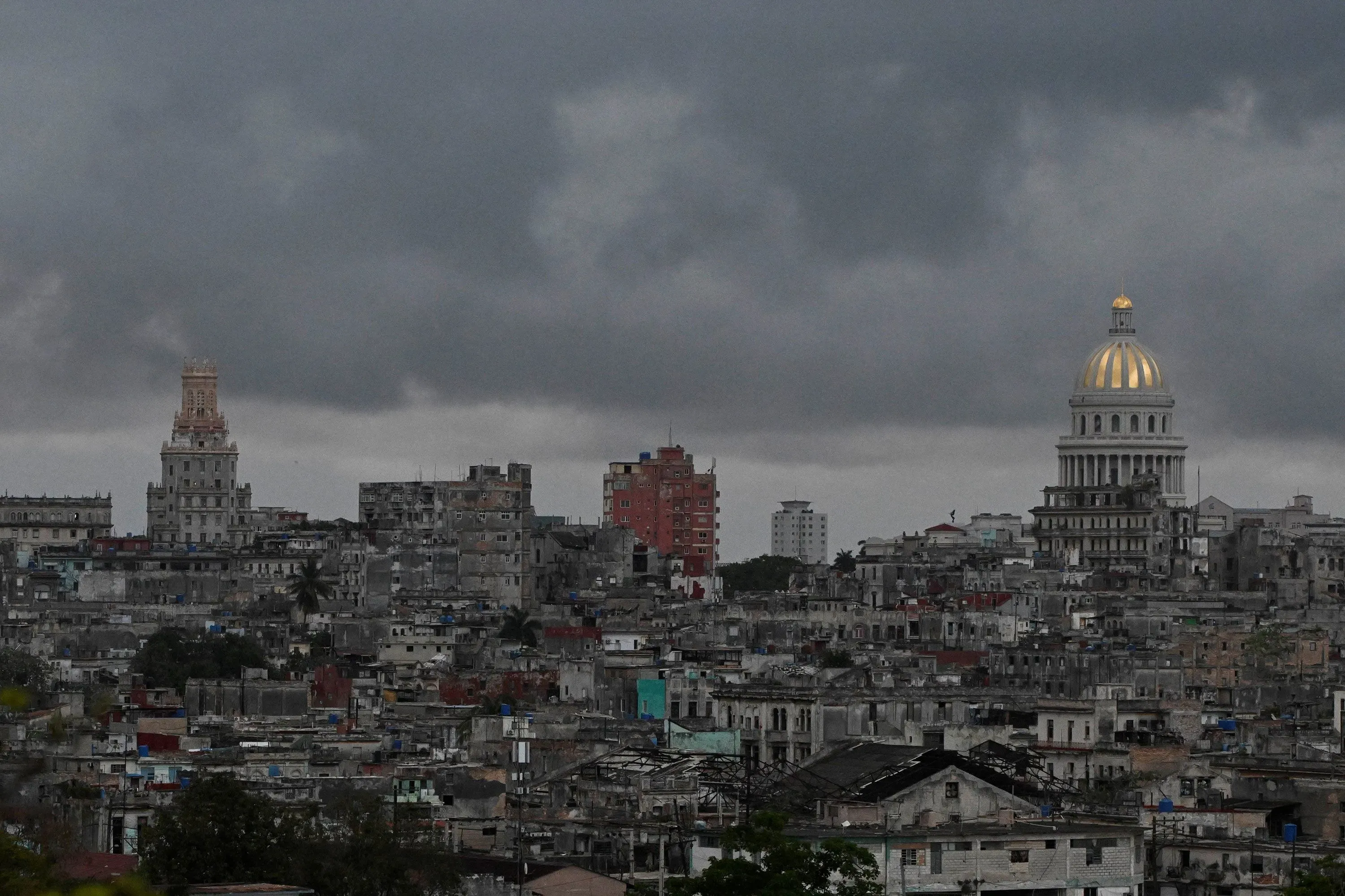 مشهد لمدينة هافانا، كوبا، يظهر المباني القديمة والتاريخية تحت سماء غائمة، مما يعكس التحديات الاقتصادية والسياسية التي تواجهها البلاد.