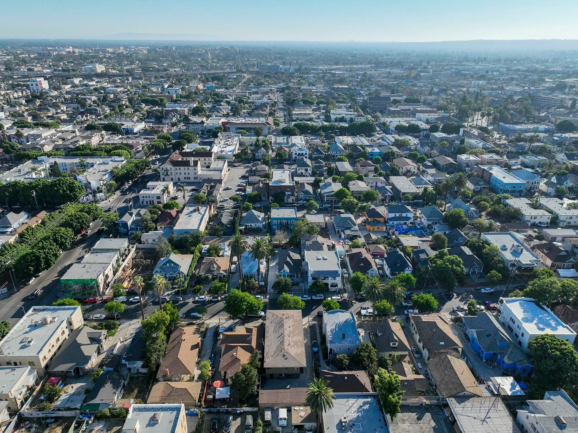 منظر جوي لحي سكني يضم منازل متعددة الطوابق وأشجار، يُظهر تأثير الإغلاق الحكومي على سوق العقارات.