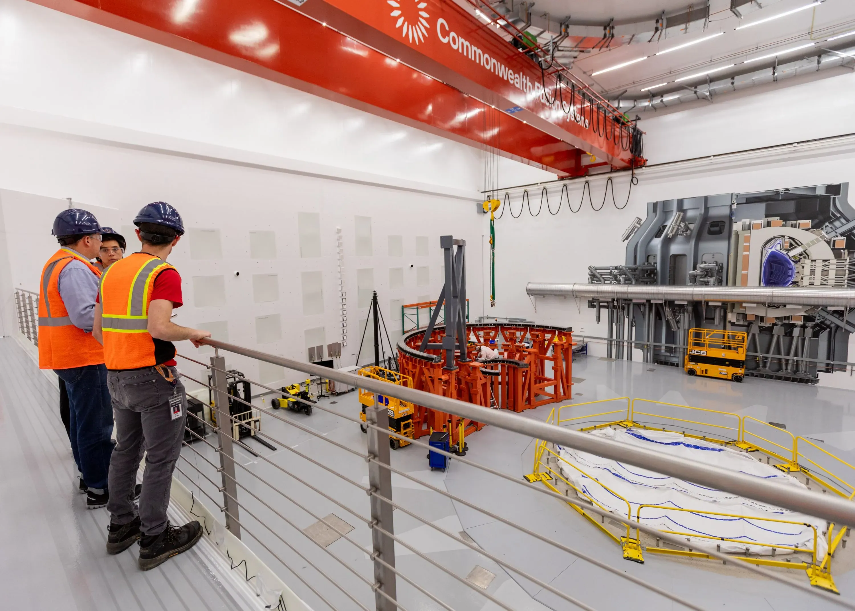 تظهر الصورة مجموعة من المهندسين في موقع بناء جهاز التوكاماك التابع لشركة Commonwealth Fusion Systems، الذي يهدف لتوليد طاقة الاندماج النووي.