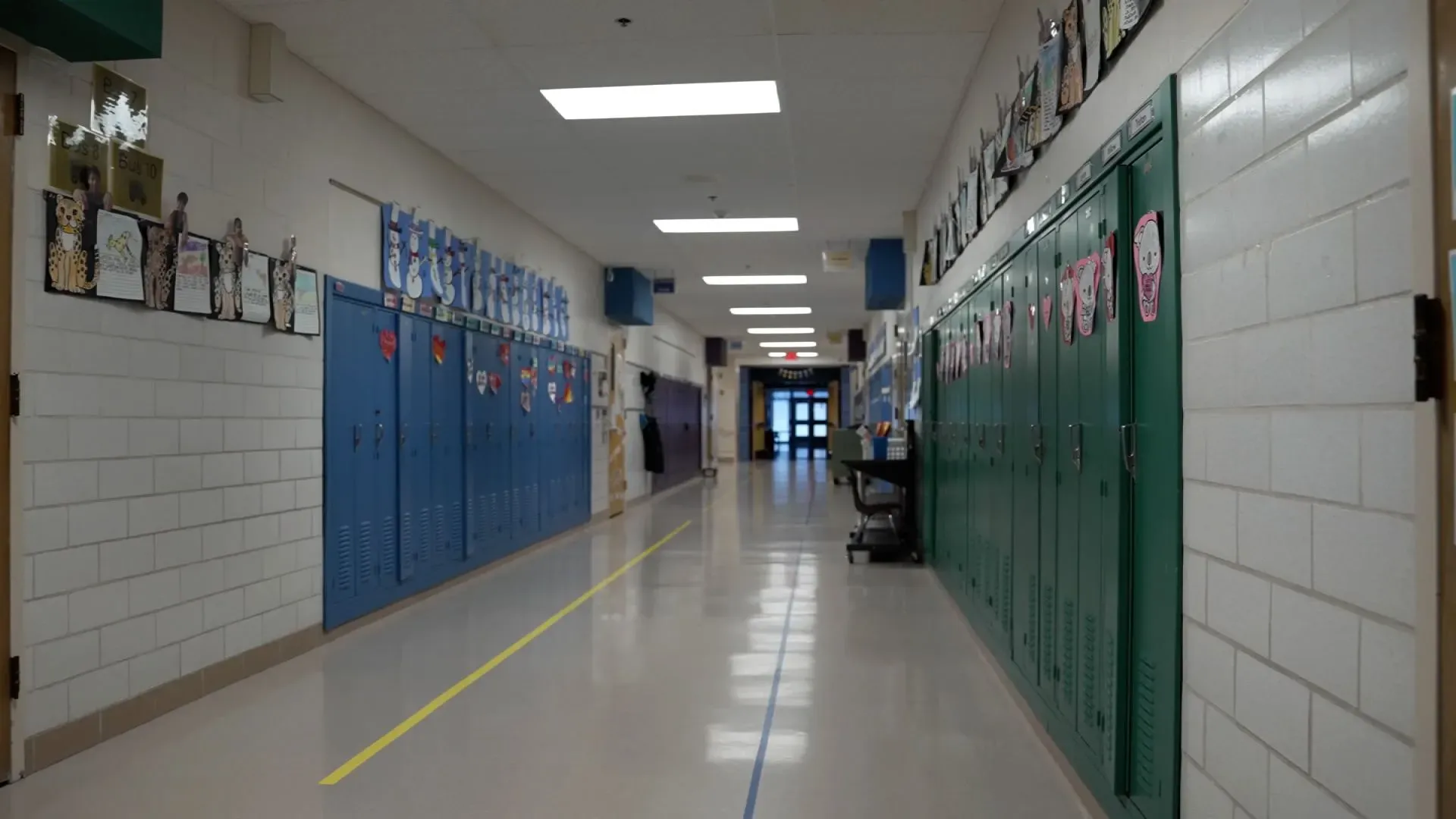 ممر مدرسة هياواثا كوليجيت الثانوية في مينيابوليس، يظهر خزائن ملونة مع رسومات طلابية، يعكس أجواء القلق والخوف بسبب عمليات الاحتجاز.