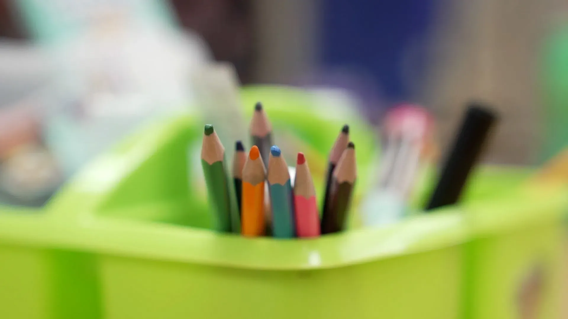 مجموعة من أقلام التلوين داخل حاوية خضراء، تعكس أجواء القلق في مدرسة هياواثا كوليجيت الثانوية بمينيابوليس في ظل التوترات المتعلقة بالهجرة.