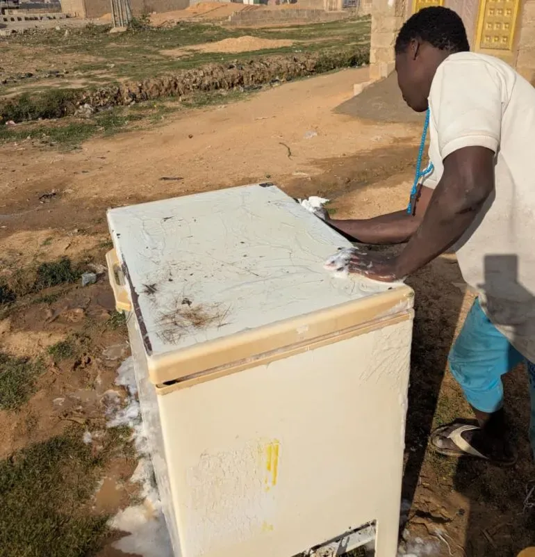 شخص يقوم بتنظيف ثلاجة مستعملة في سوق سابون غاري بكانو، نيجيريا، حيث يشتري الكثيرون الأجهزة المستعملة رغم مخاطرها.