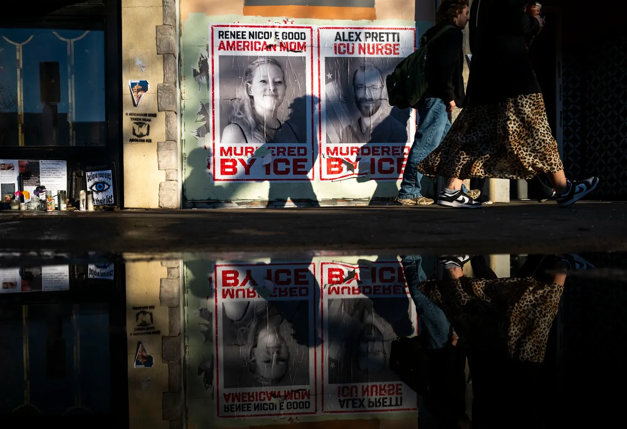 ملصقات تحمل صور رينيه جود وأليكس بريتي، اللذين قُتلا على يد عملاء الهجرة، مع مشاة يمرون بجوارها في مينيابوليس.