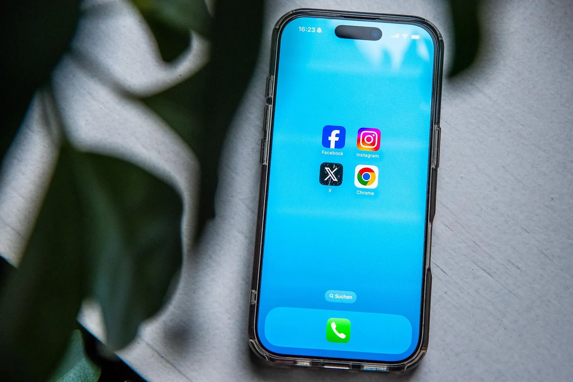 هاتف ذكي يعرض تطبيقات فيسبوك وإنستغرام وX ومتصفح كروم، مع خلفية زرقاء، يرمز إلى تأثير التكنولوجيا على الرقابة والمحتوى.