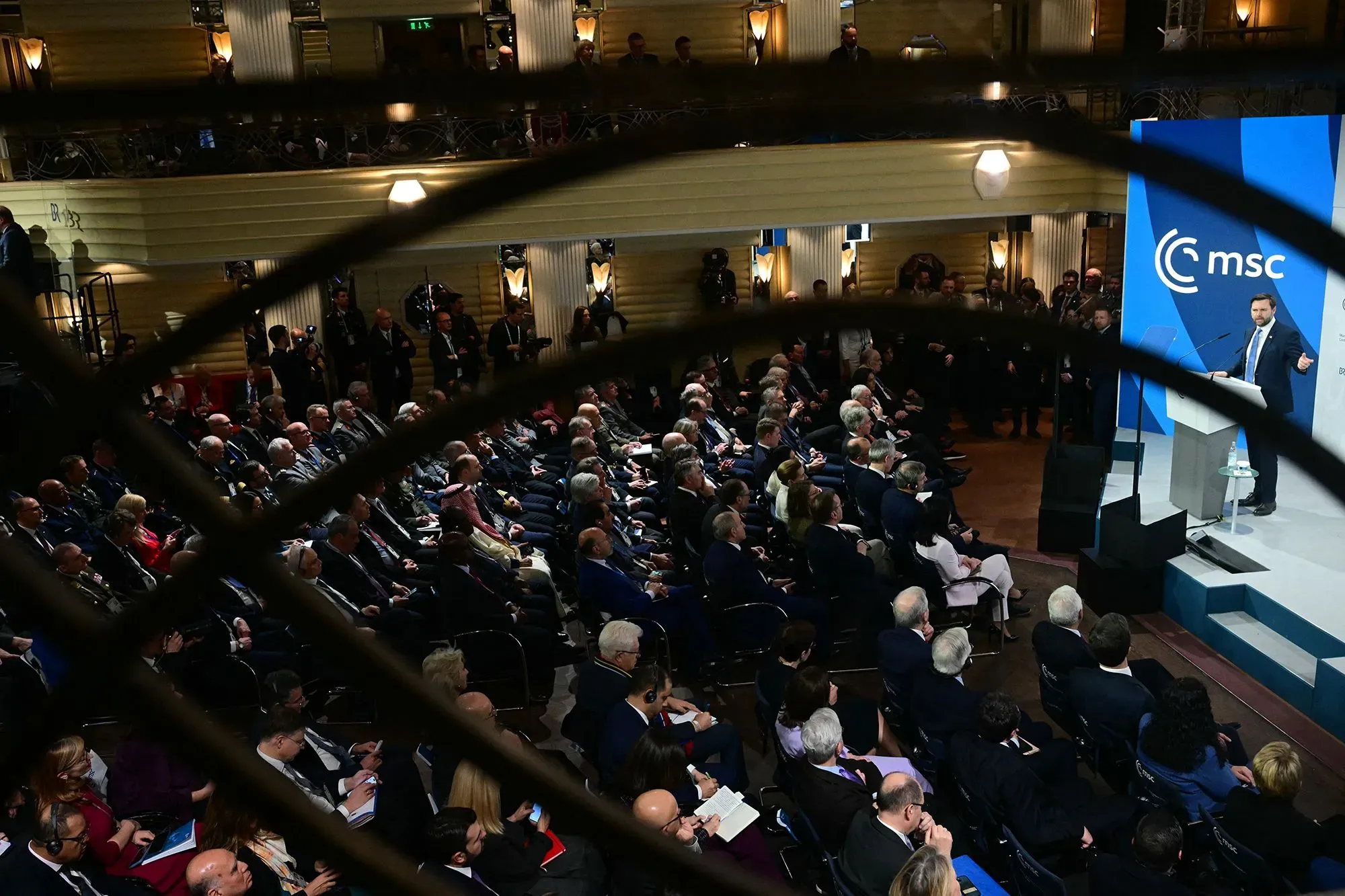 مؤتمر دولي يتحدث فيه شخصية بارزة أمام جمهور كبير، مع التركيز على قضايا تنظيم التكنولوجيا والعلاقات بين الولايات المتحدة والاتحاد الأوروبي.