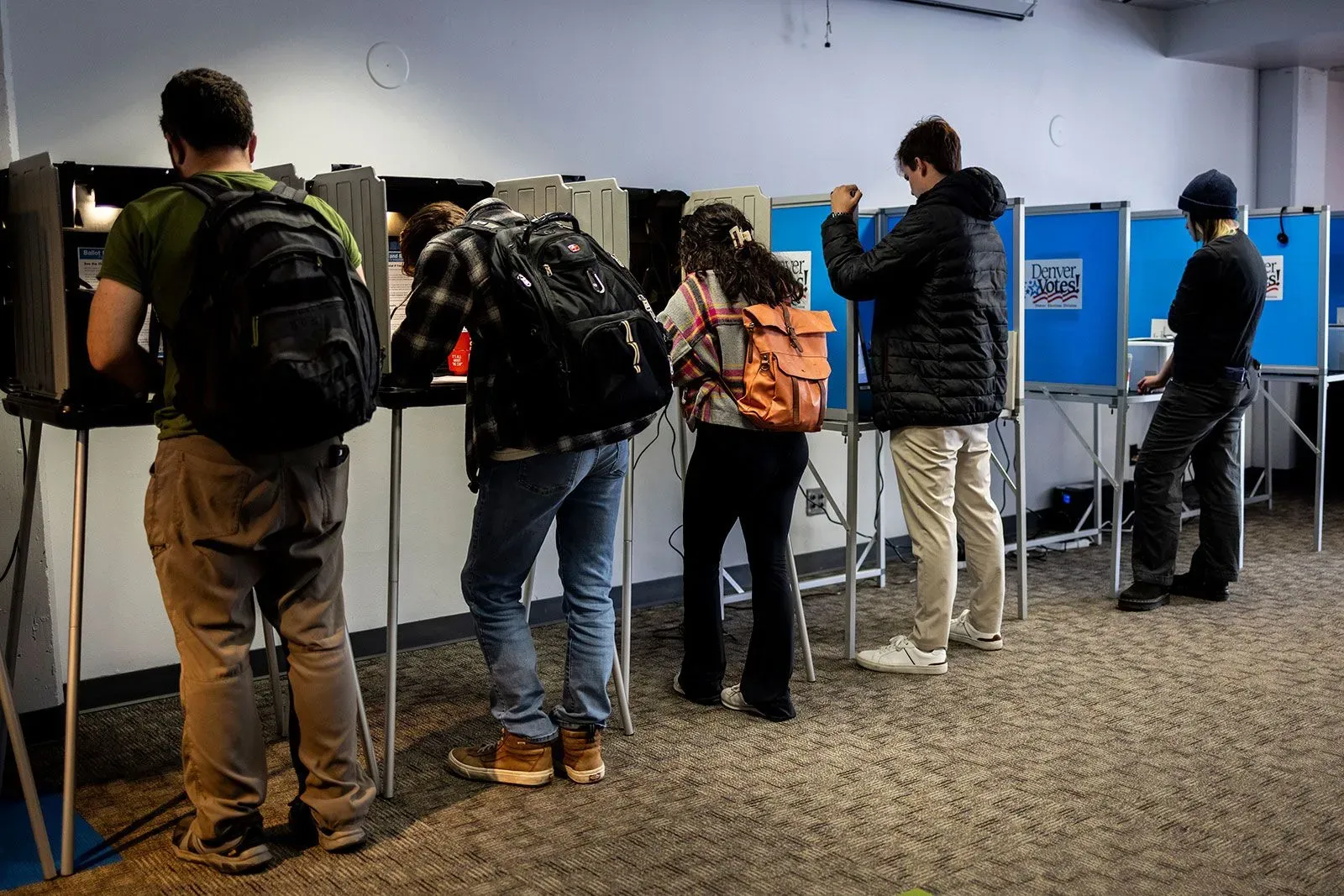 مواطنون يصوتون في مركز انتخابي بكولورادو، مع التركيز على أهمية نزاهة الانتخابات وسط محاولات للتدخل في العملية الانتخابية.