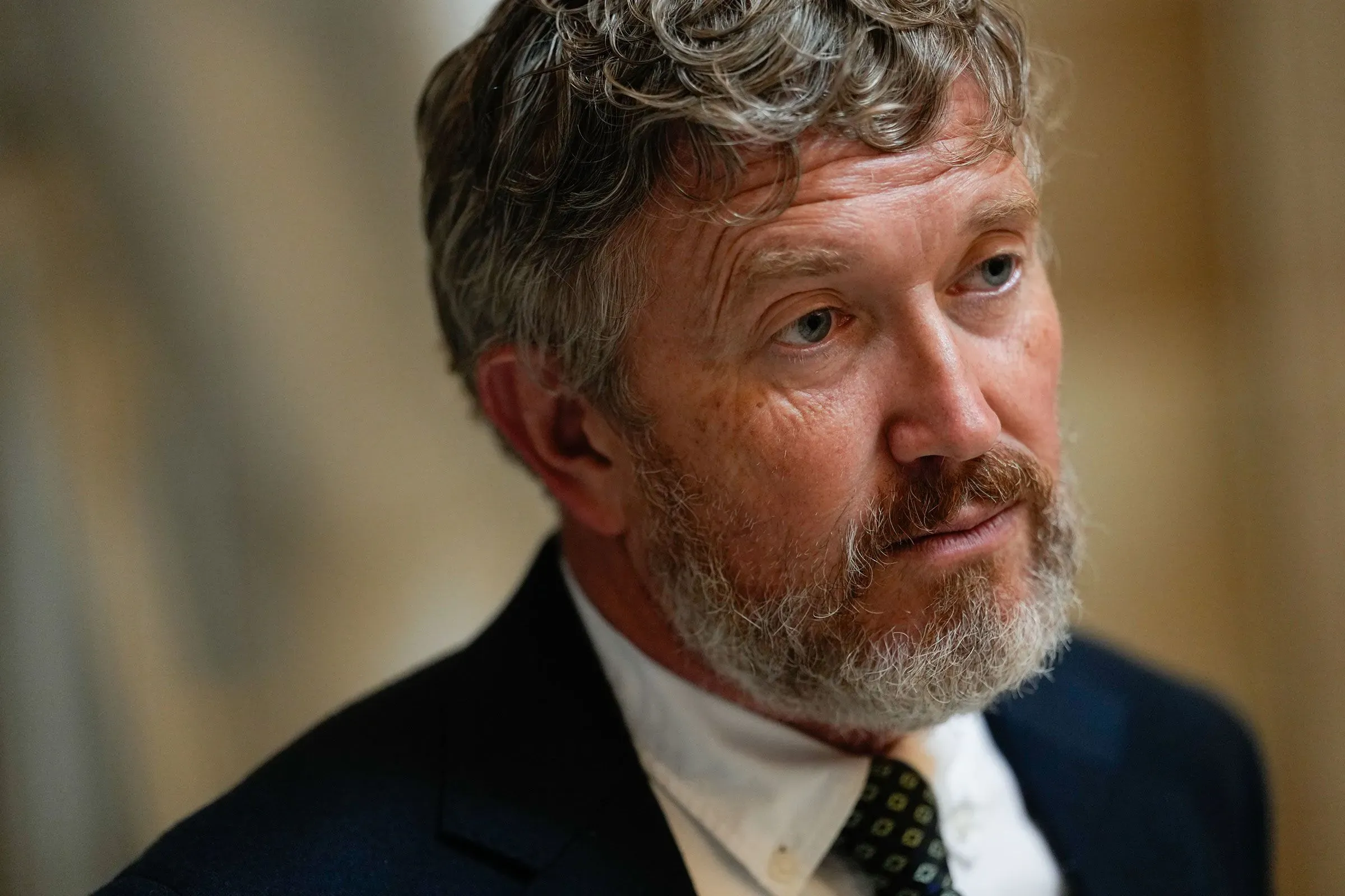 صورة لرجل ذو لحية وشعر رمادي، يبدو في حالة تفكير عميق. تعكس تعابيره التوتر في ظل مناقشات قانونية حول سلطات الإنفاق.