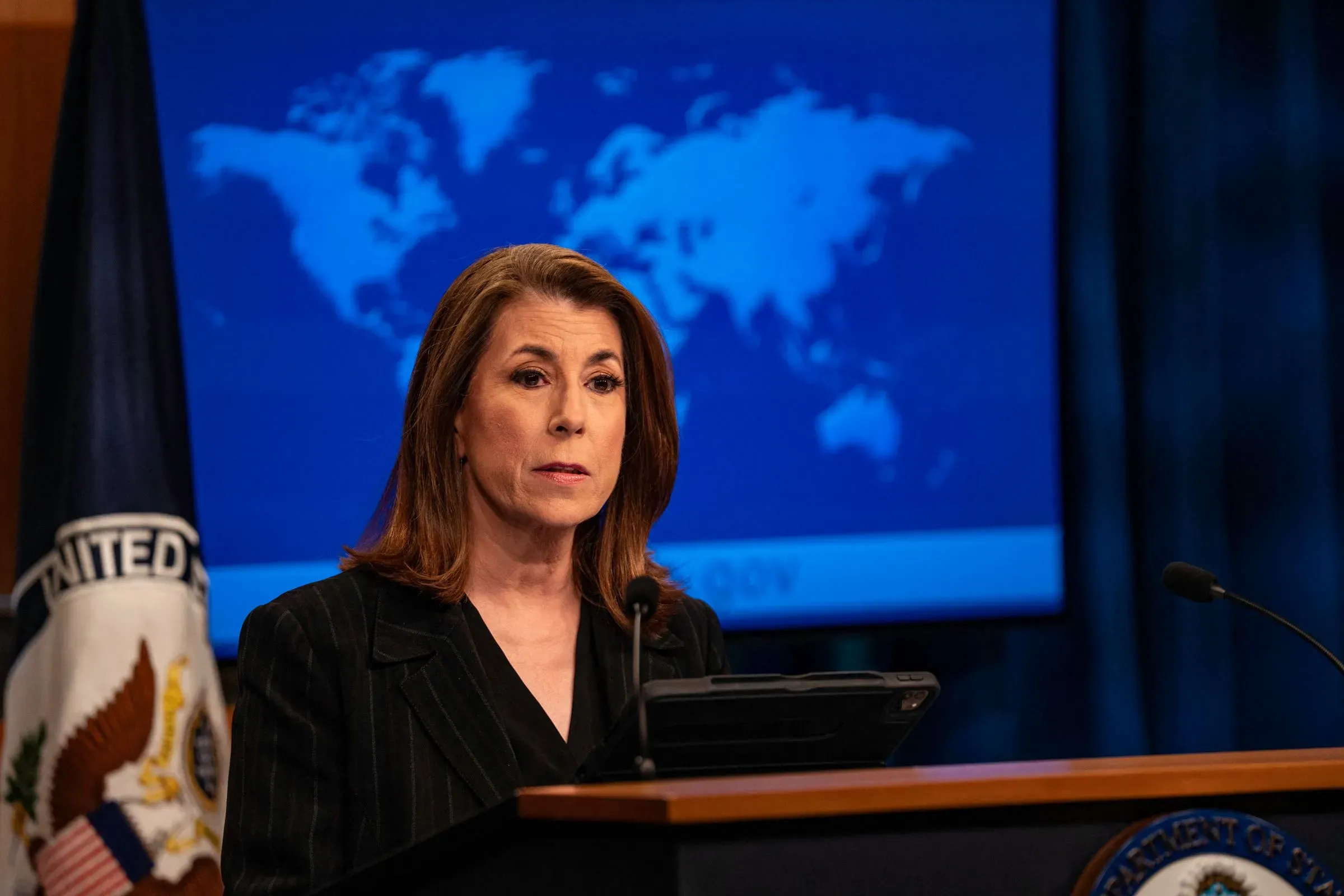 تظهر تامي بروس، نائبة مندوب الولايات المتحدة لدى الأمم المتحدة، خلال مؤتمر صحفي في وزارة الخارجية، مع خريطة العالم خلفها.