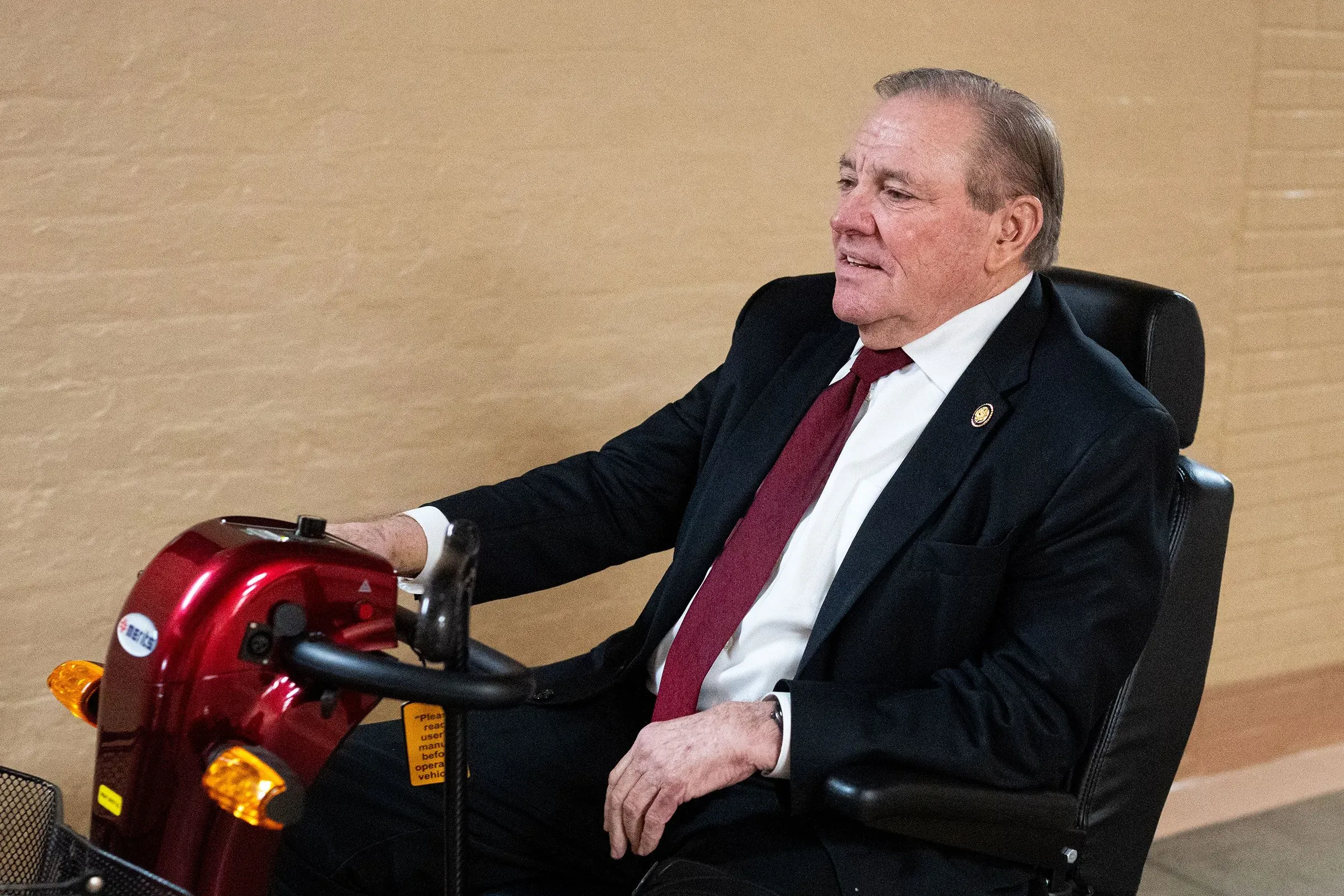 النائب نيل دن من فلوريدا، البالغ من العمر 73 عامًا، يجلس على عربة كهربائية، يظهر العزيمة رغم حالته الصحية.