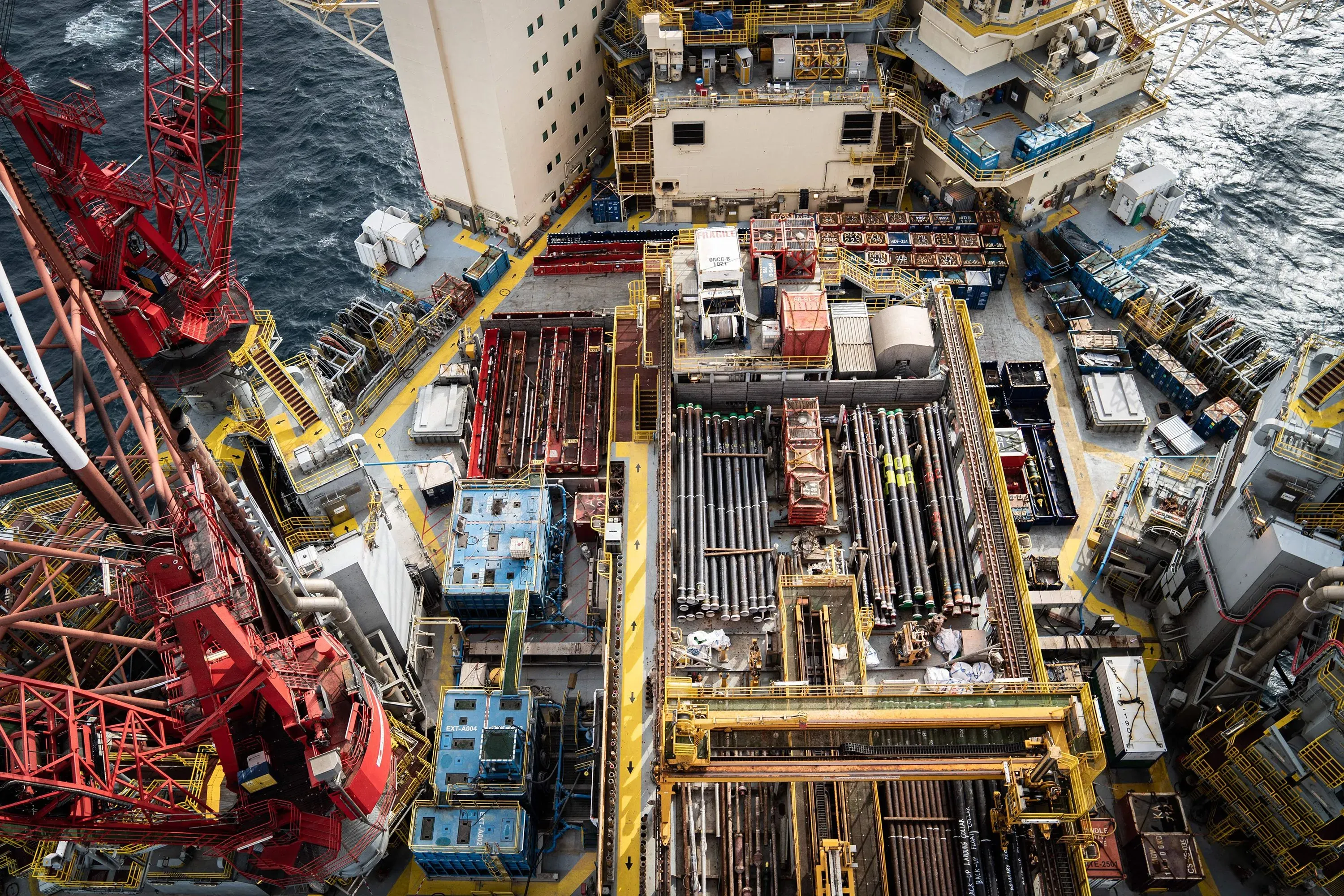 صورة لموقع منصة بحرية تحتوي على معدات حفر وأنابيب، مع مشهد للبحر في الخلفية، تعكس جهود أوروبا في تطوير طاقة الرياح البحرية.