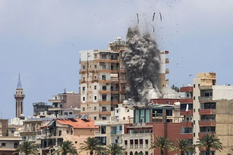 انفجار قوي في مدينة صور اللبنانية، مع تصاعد الدخان من مبنى متضرر، في سياق الهجمات الإسرائيلية المتكررة على المنطقة.