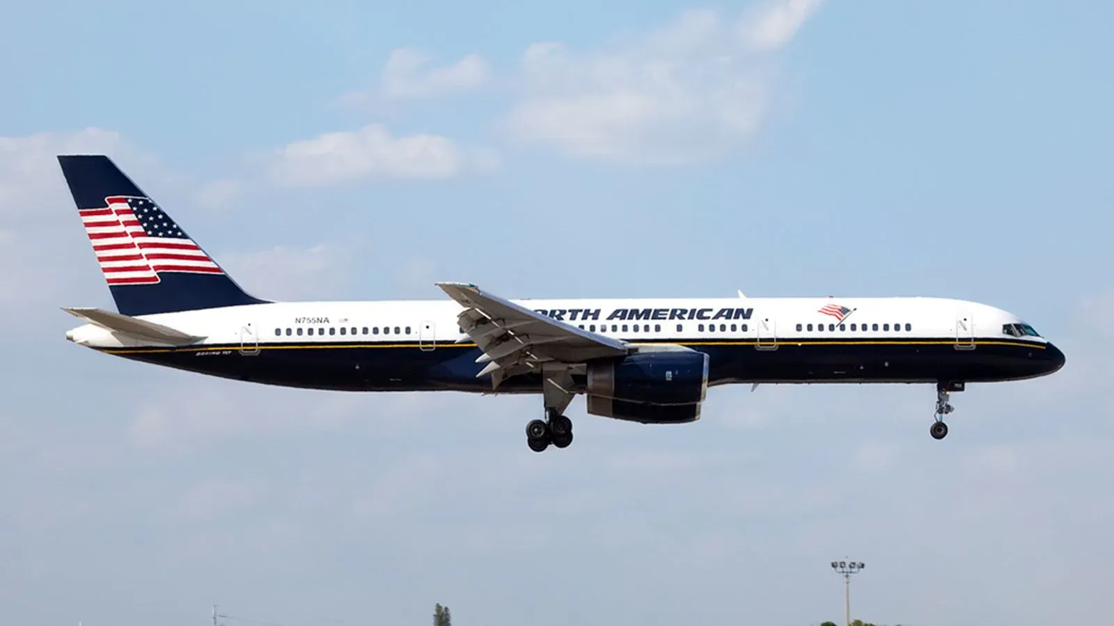 طائرة بوينغ 757 تابعة لشركة خطوط أمريكا الشمالية، تحمل علم الولايات المتحدة، تظهر أثناء الهبوط في السماء الزرقاء.