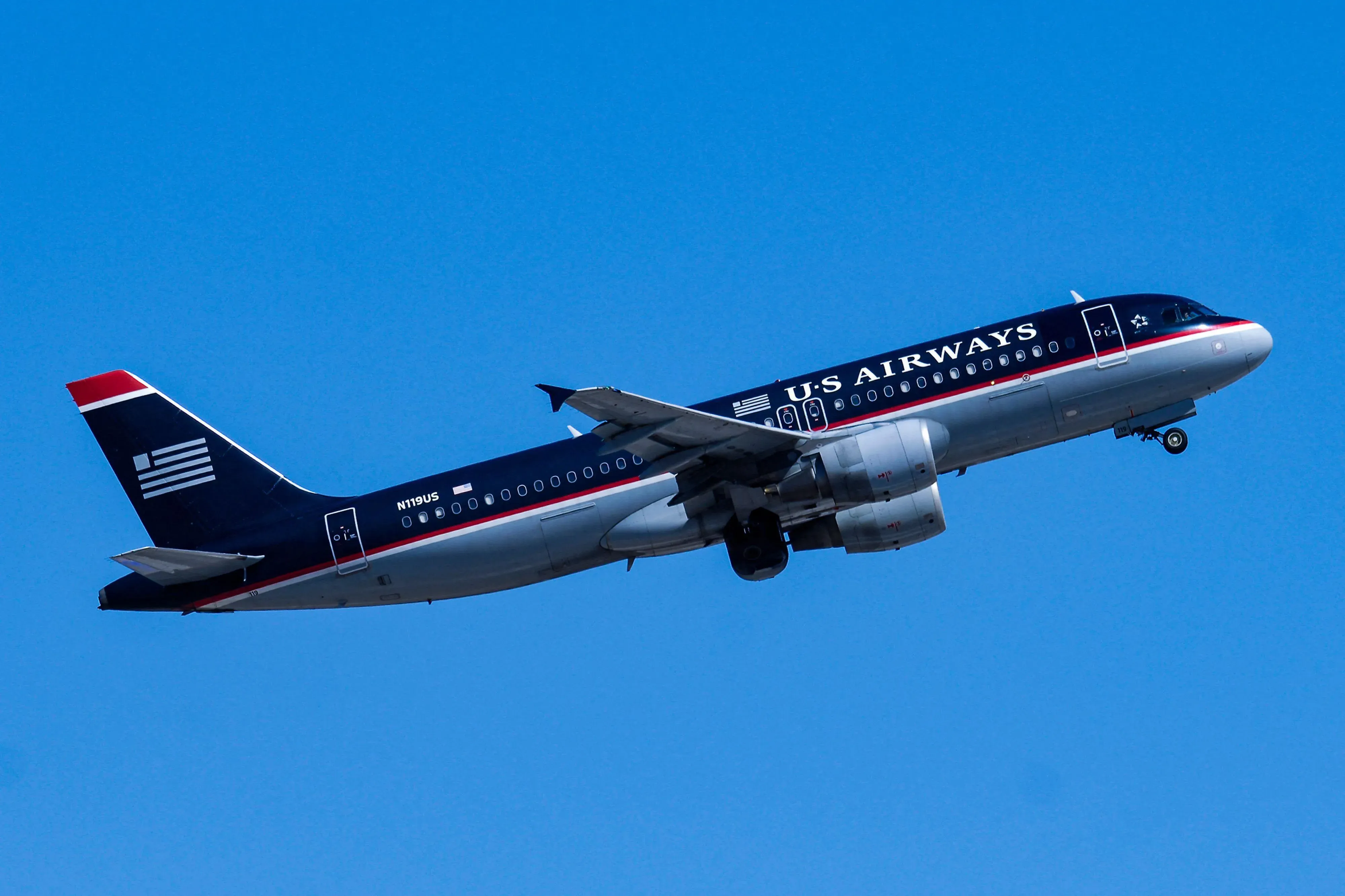 طائرة تابعة لشركة يونايتد إيرلاينز ترتفع في السماء، تحمل طلاءً باللونين الأزرق الداكن والأحمر، مما يبرز التصميم التقليدي لوسائل النقل الجوية الأمريكية.